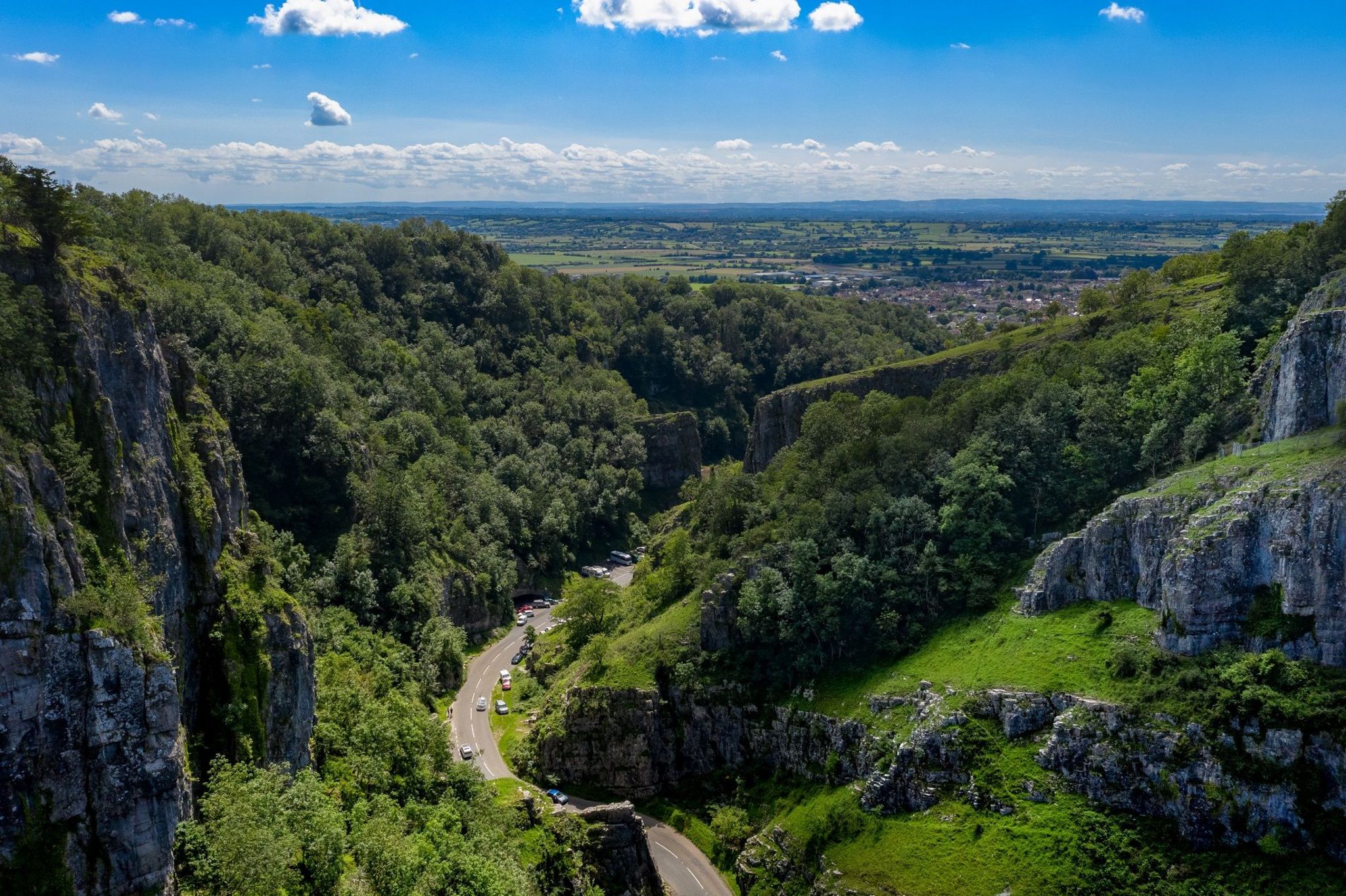 An aerial picture of Cheddar Gorge on a sunny day with the Somerset Levels in the distance