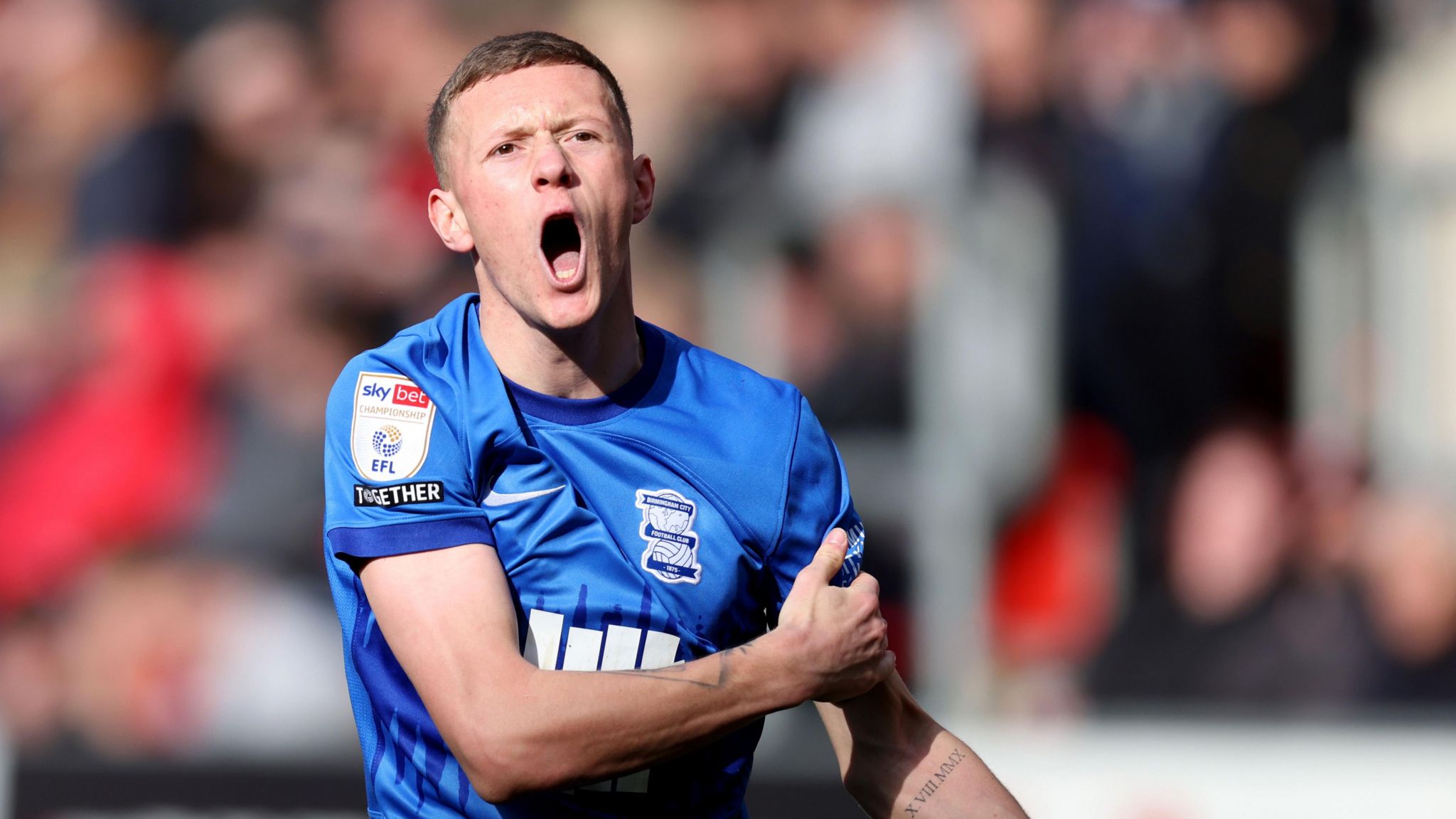 Jay Stansfield, wearing Birmingham's home kit in a game against Rotherham, shouts to an off camera team-mate 