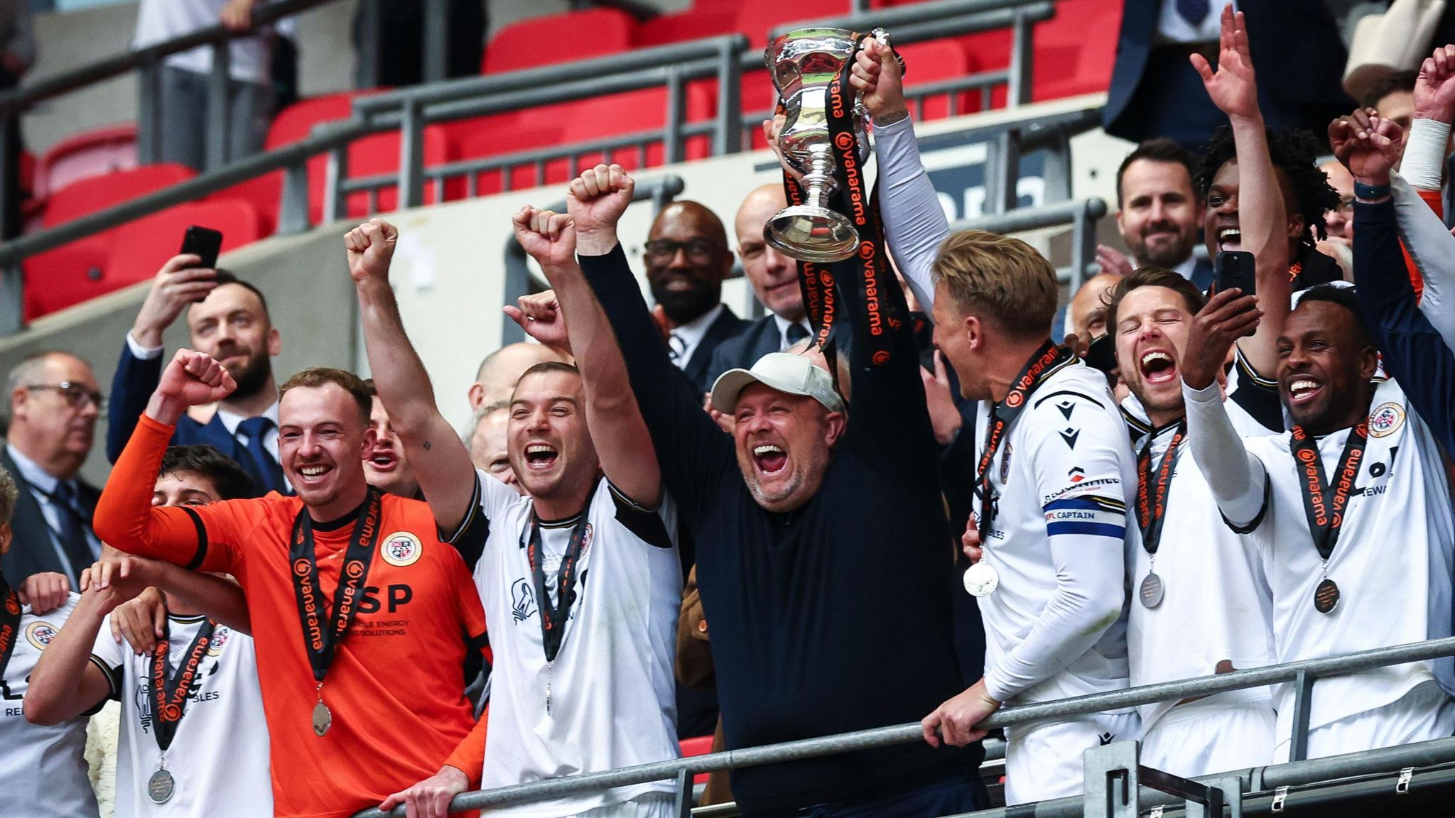 Andy Woodman holds the National League promotion final trophy aloft with Bromley's players