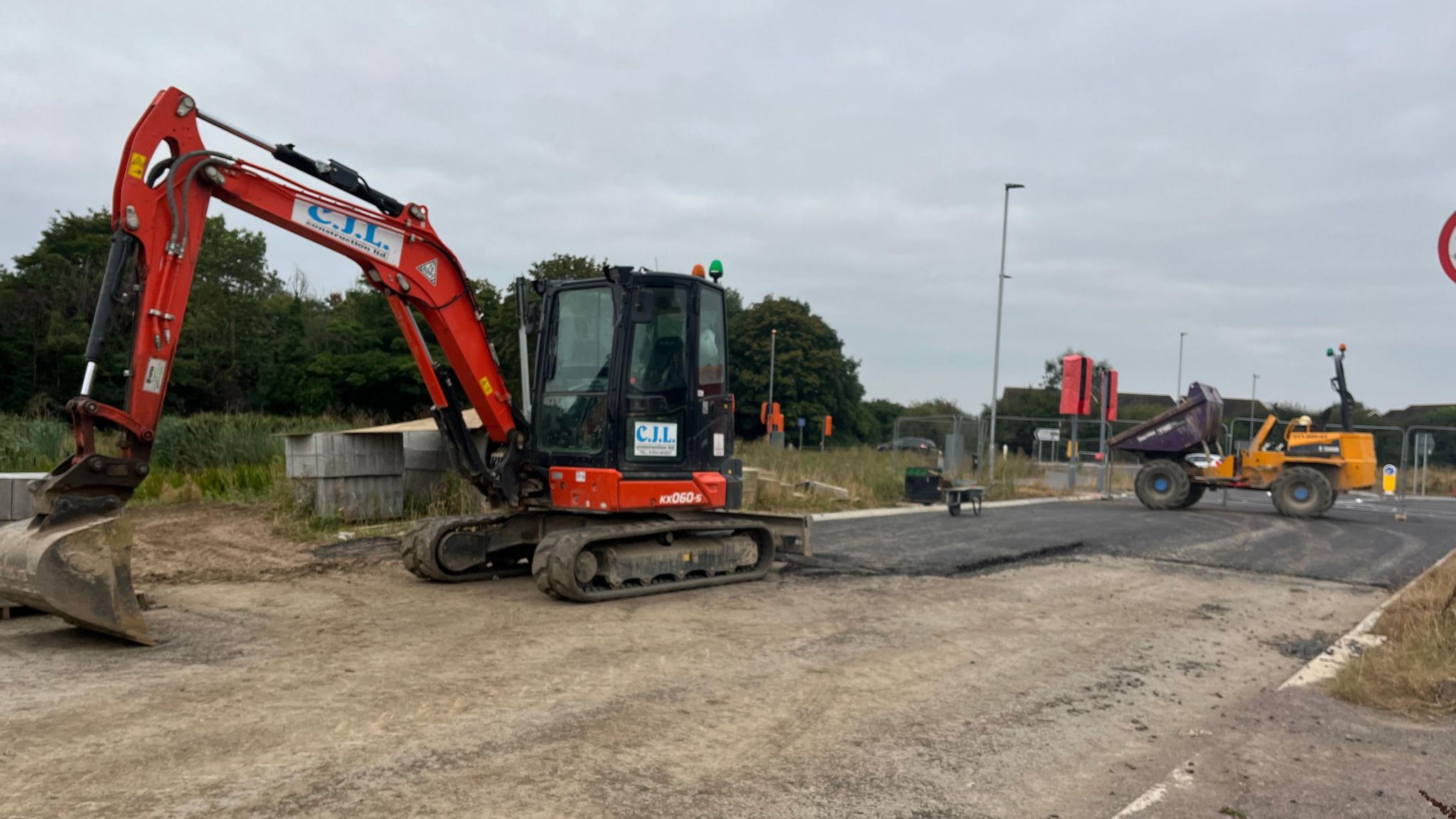 A digger on a rough service ahead of being paved over