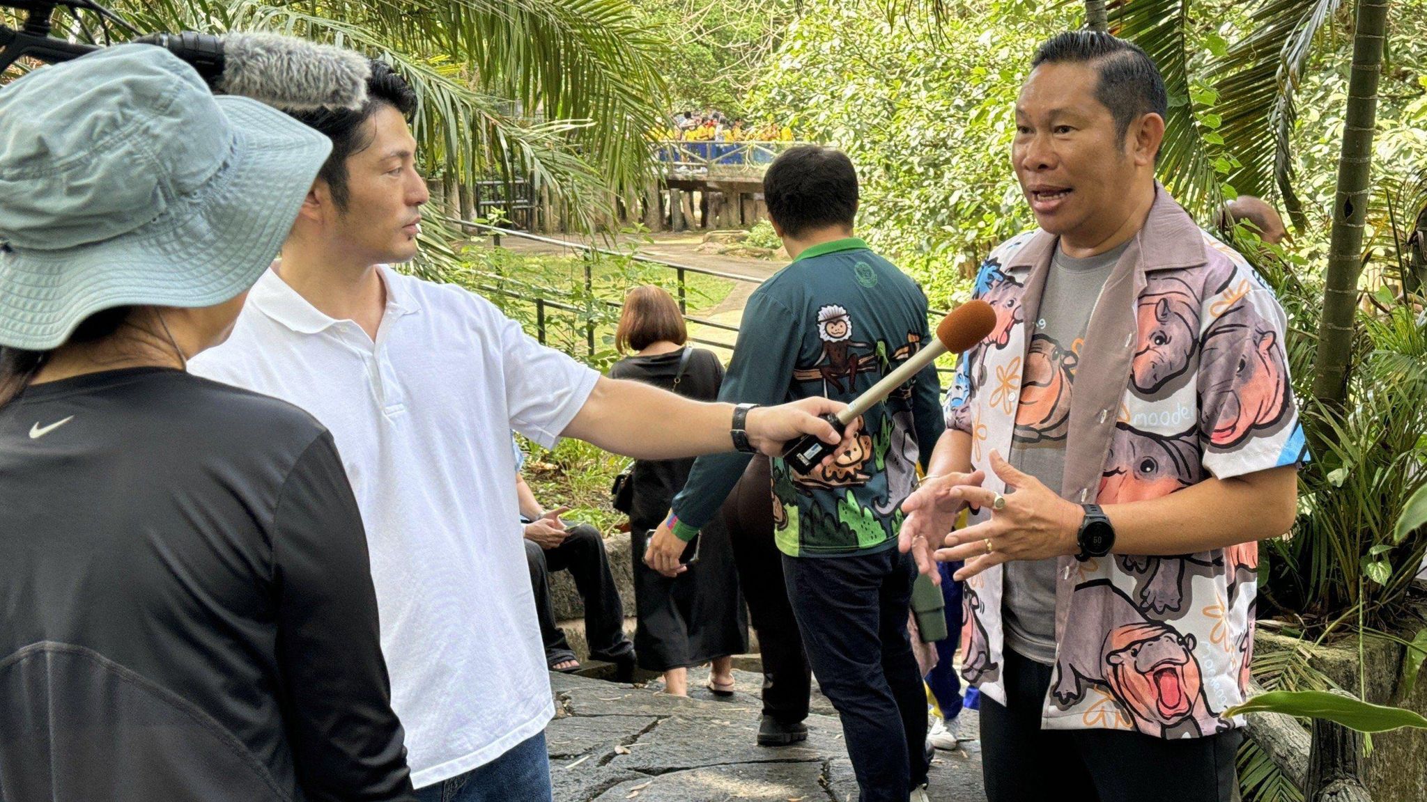 Zoo director Narongwit Chodchoi, wearing a hippo patterned shirt, being interviewed by a Japanese television crew.