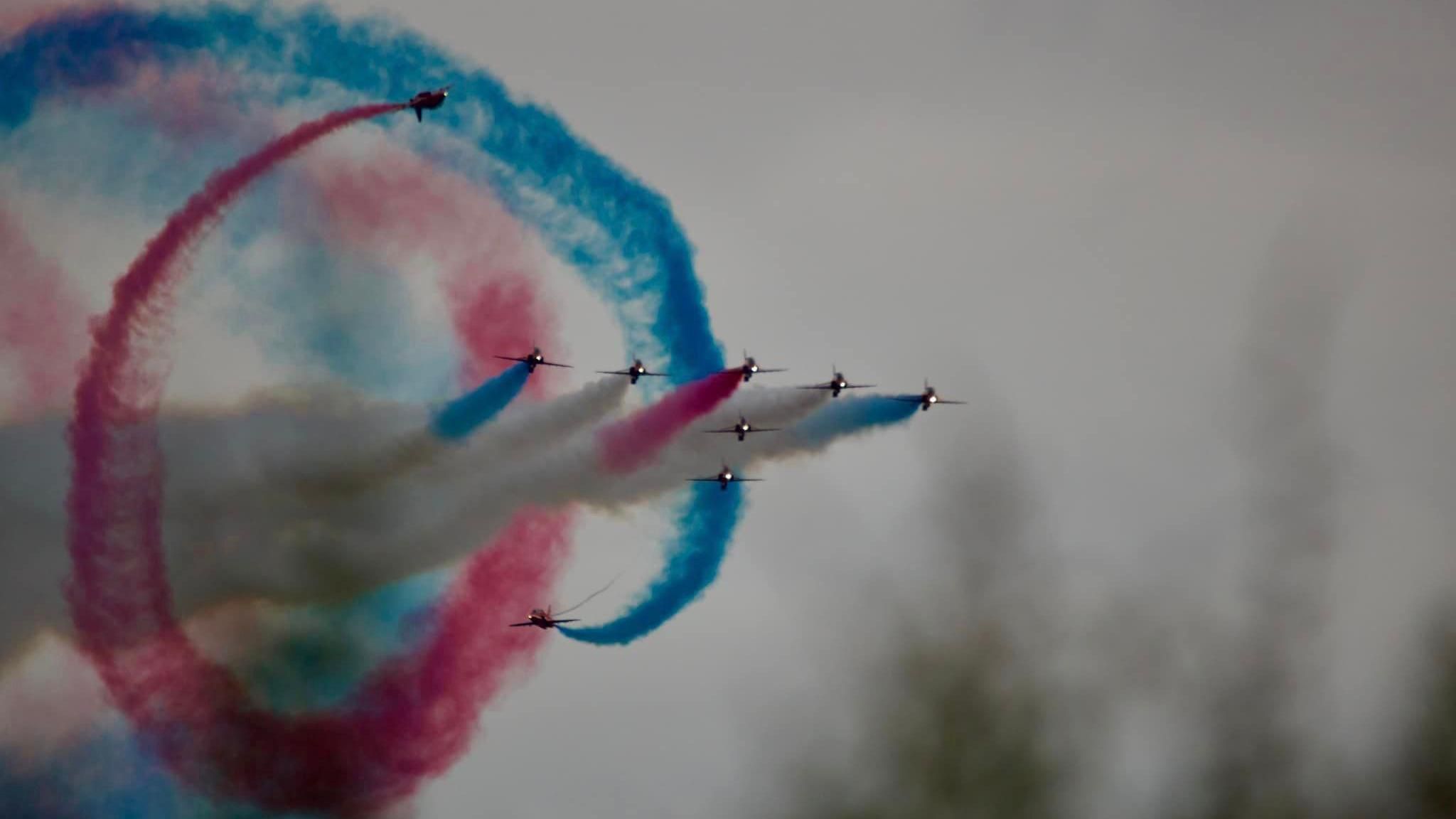 The Red Arrows flying, surrounded by swirls of smoke