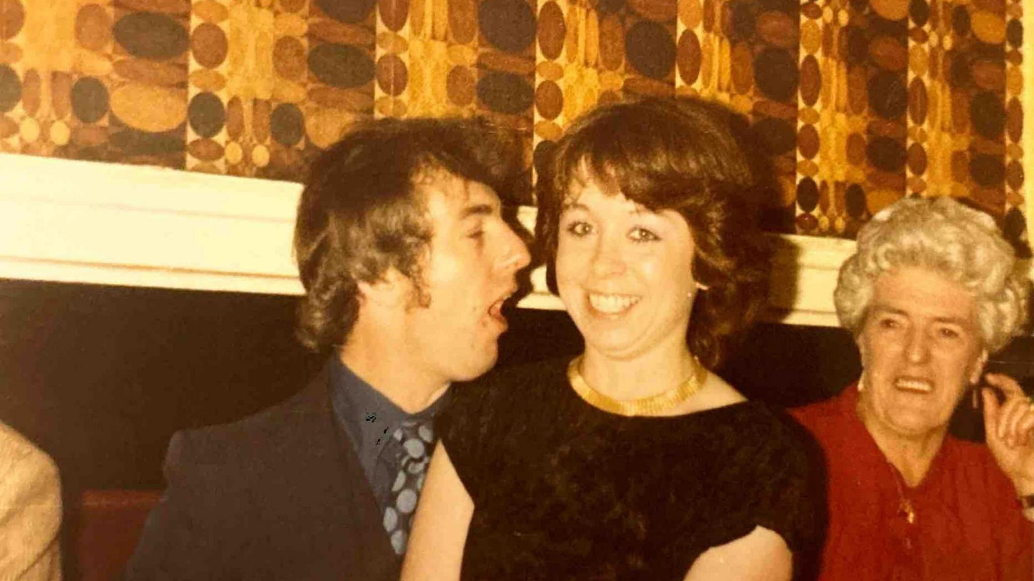 A man and a woman at a party in the 1970s