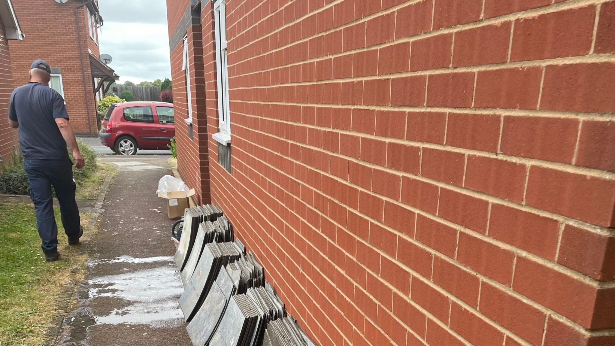 Grey tiles lined up against a brick wall