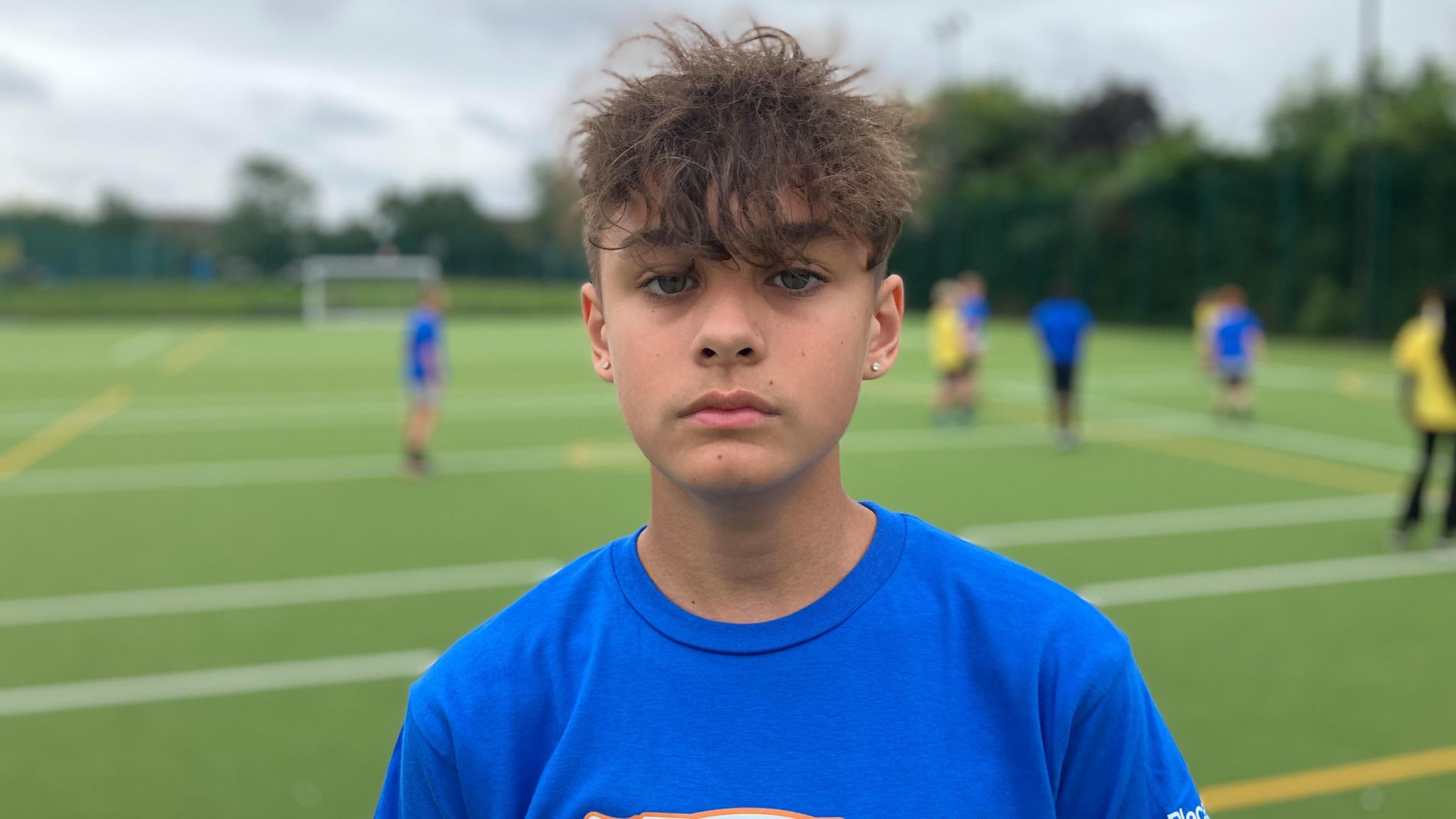 Boy in blue tshirt on football pitch