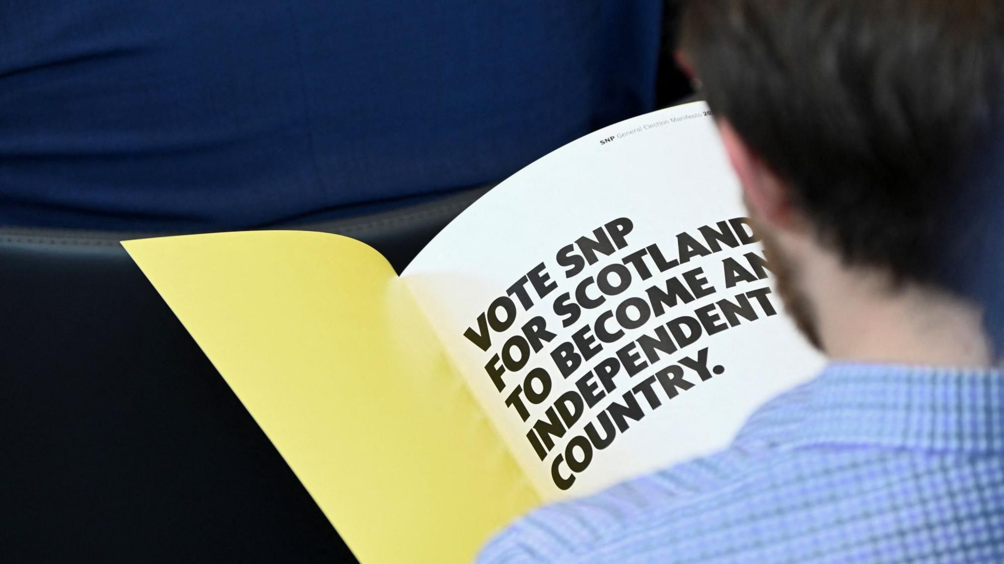 A man reads the SNP manifesto