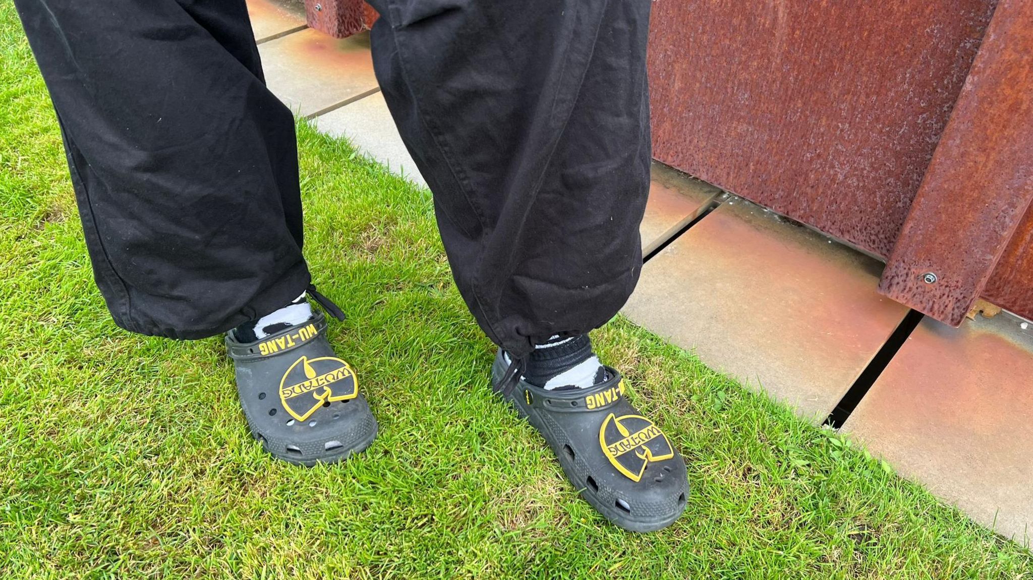 A close up of a pair of crocs decorated with Wu Tang Clan symbols