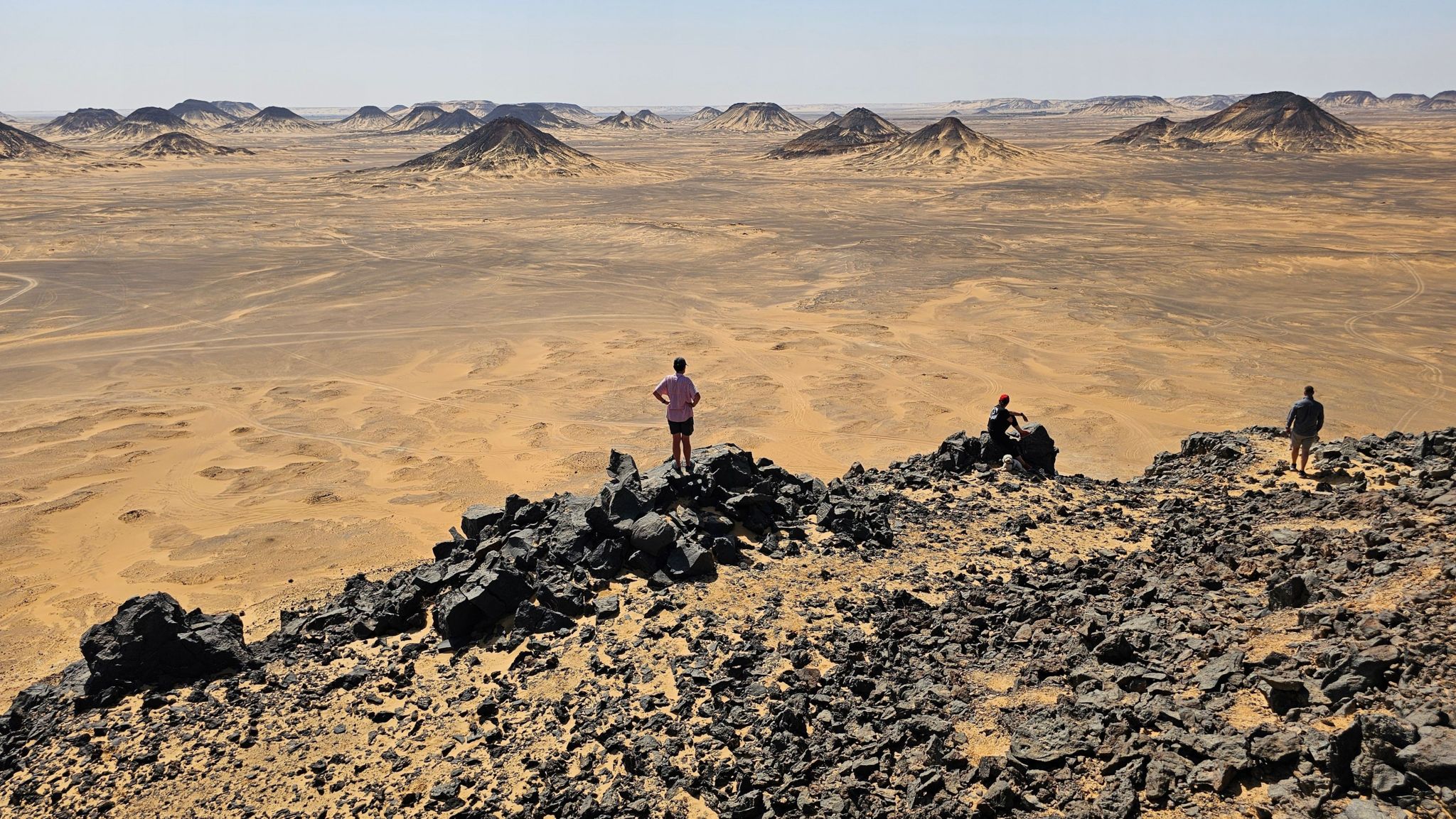 Three people looking out across the desert in Egypt