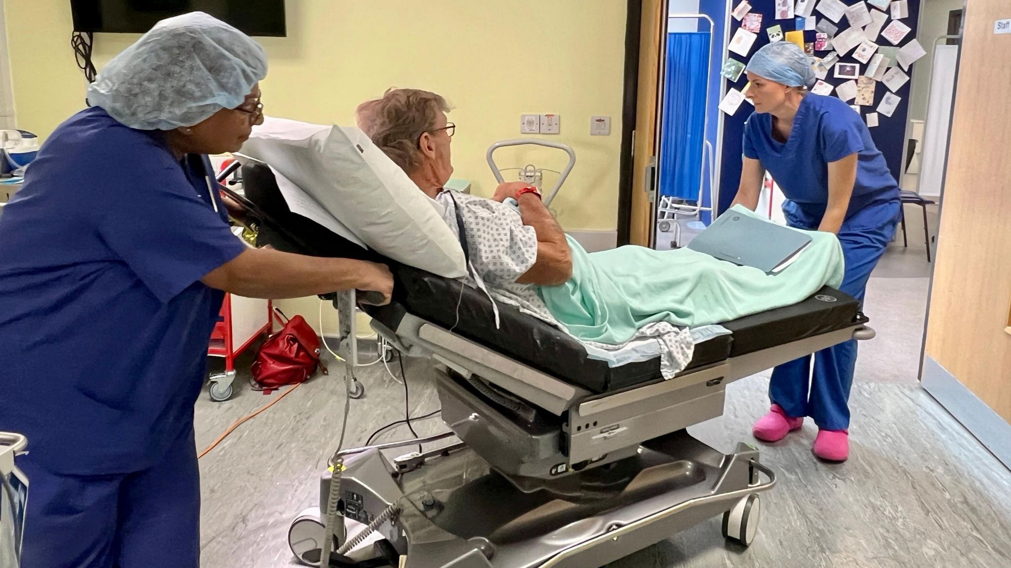 Patient Andrew Downes is wheeled on a bed around the surgical unit