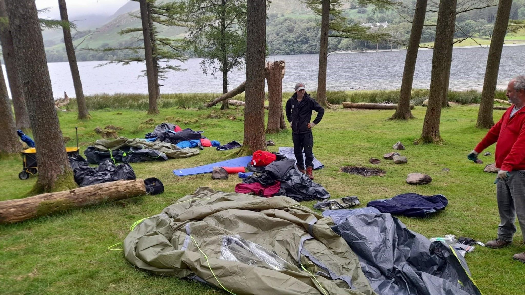 Camping equipment dumped at the side of a lake.