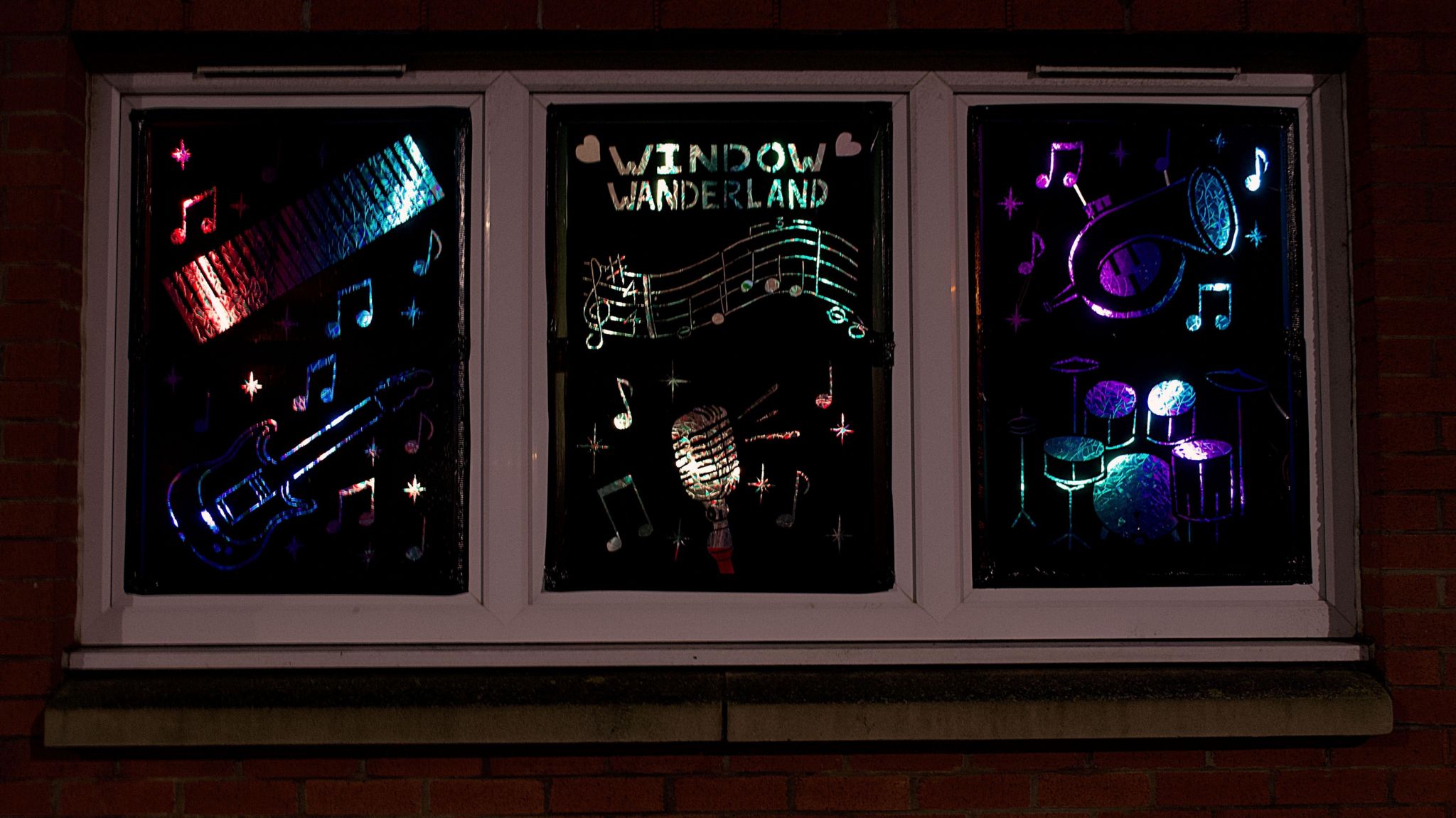 Glittering musical instruments light up three windows alongside a 'Window Wonderland' tag