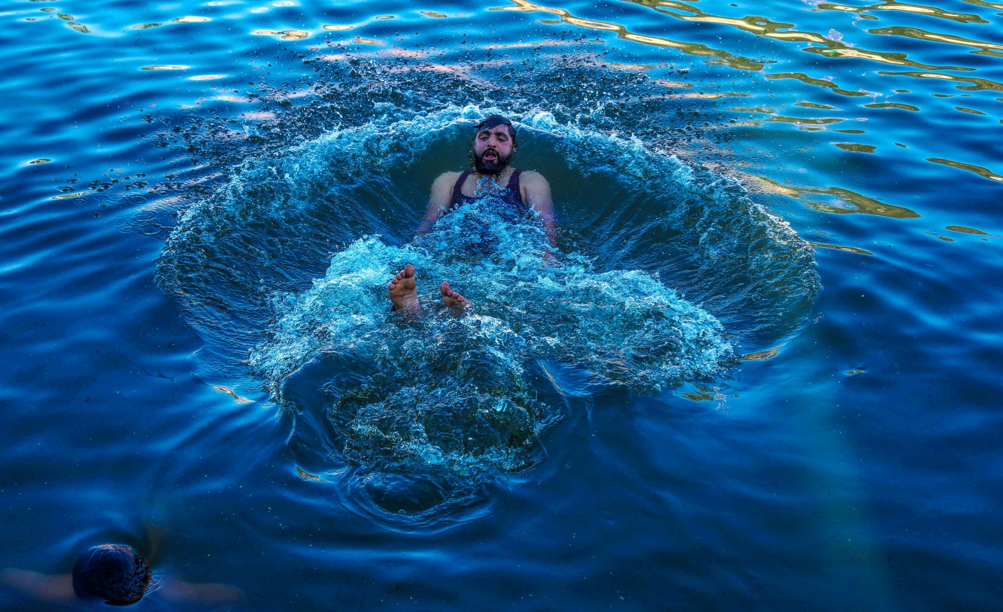 A Kashmiri man swims in waters of the Dal Lake to cool off during hot weather, in Srinagar, the summer capital of Indian Kashmir, 22 May 2024. Kashmir is witnessing above normal temperatures as the summer season gets underway. The local meteorological department has forecasted mainly dry and hot weather conditions until 28 May in the Himalayan region. Kashmir experiences hot weather conditions, Srinagar, India - 22 May 2024