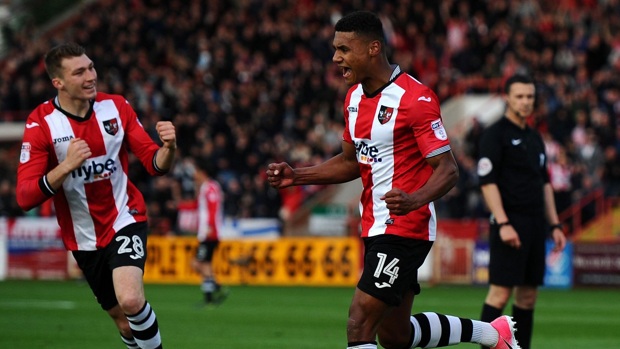 Ollie Watkins playing for Exeter, celebrates a goal as he exclaims with his fists clenched