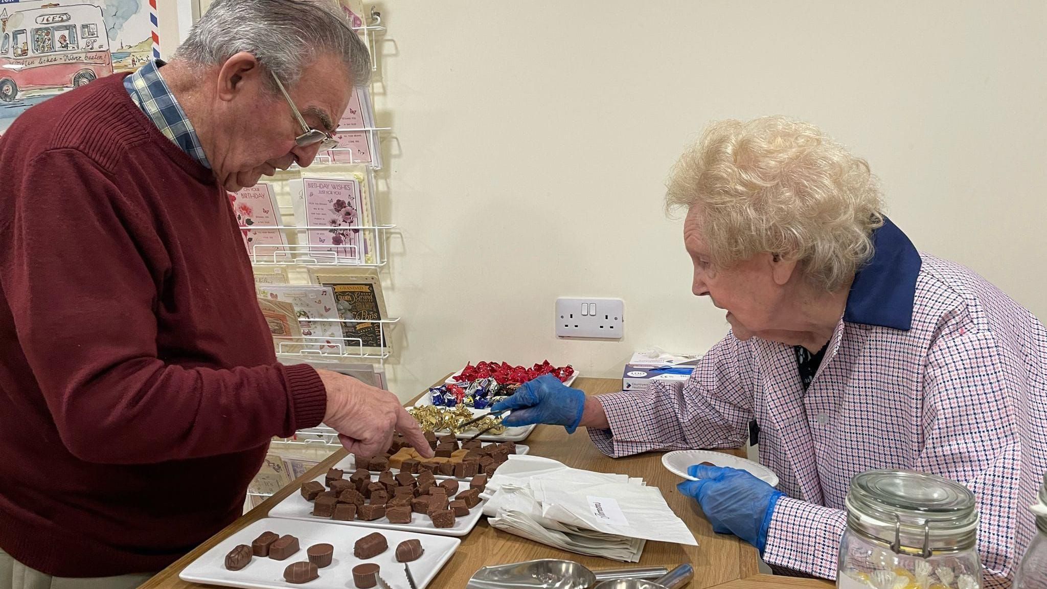 Doreen serving a fellow resident with chocolate