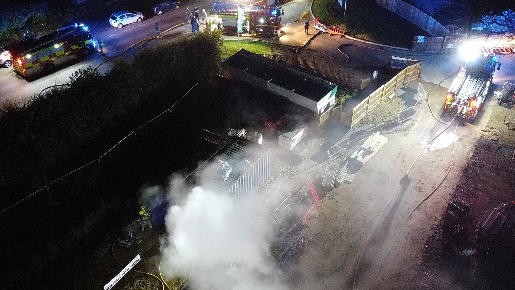 An aerial view shows smoke coming from the site