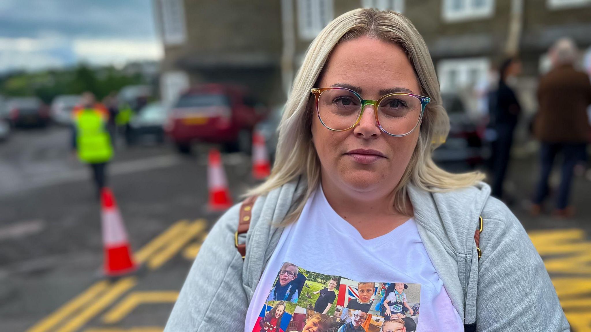 Parent wearing a white protest shirt in front of a group of protestors