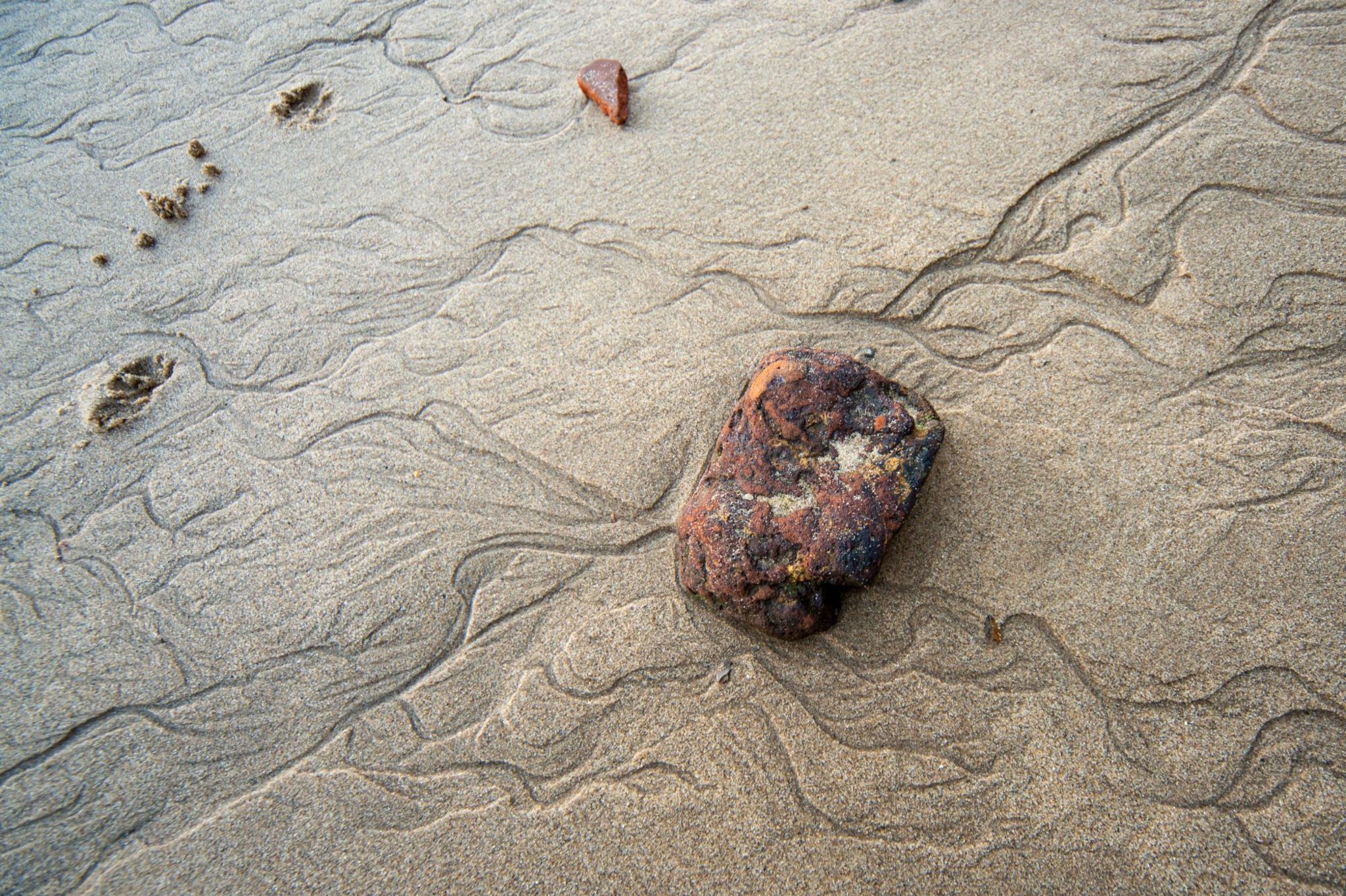 A rock surrounded by rippled sand