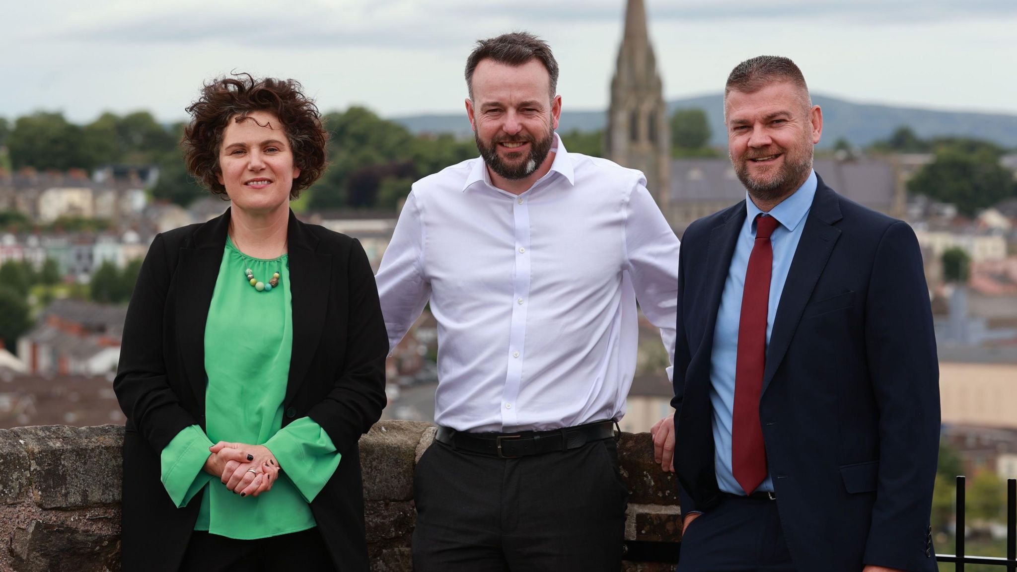 Claire Hanna, Colum Eastwood and Colin McGrath stand on the Derry Walls after the party manifesto is launched