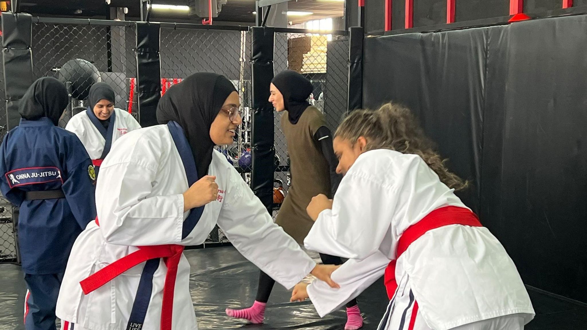 Women in martial arts uniforms engaging in combat training