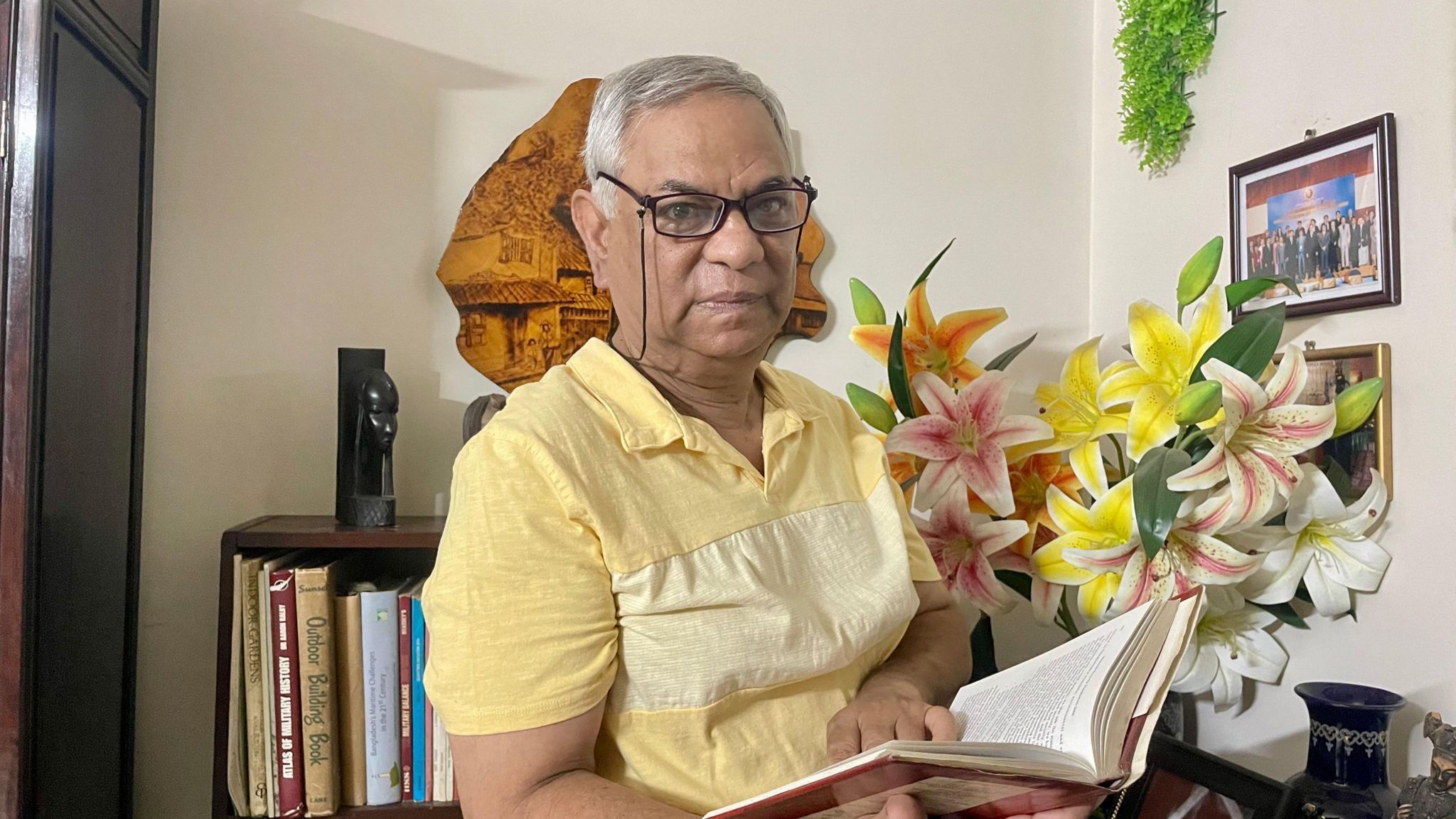 Former Bangladeshi diplomat Maroof Zaman who was abducted by Bangladeshi forces holding a book