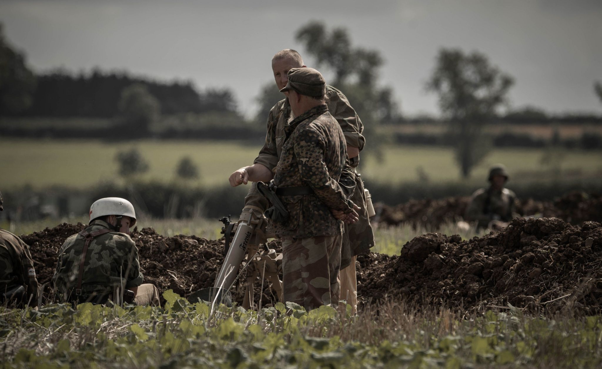 Actors dressed in camouflage clothing in a field 