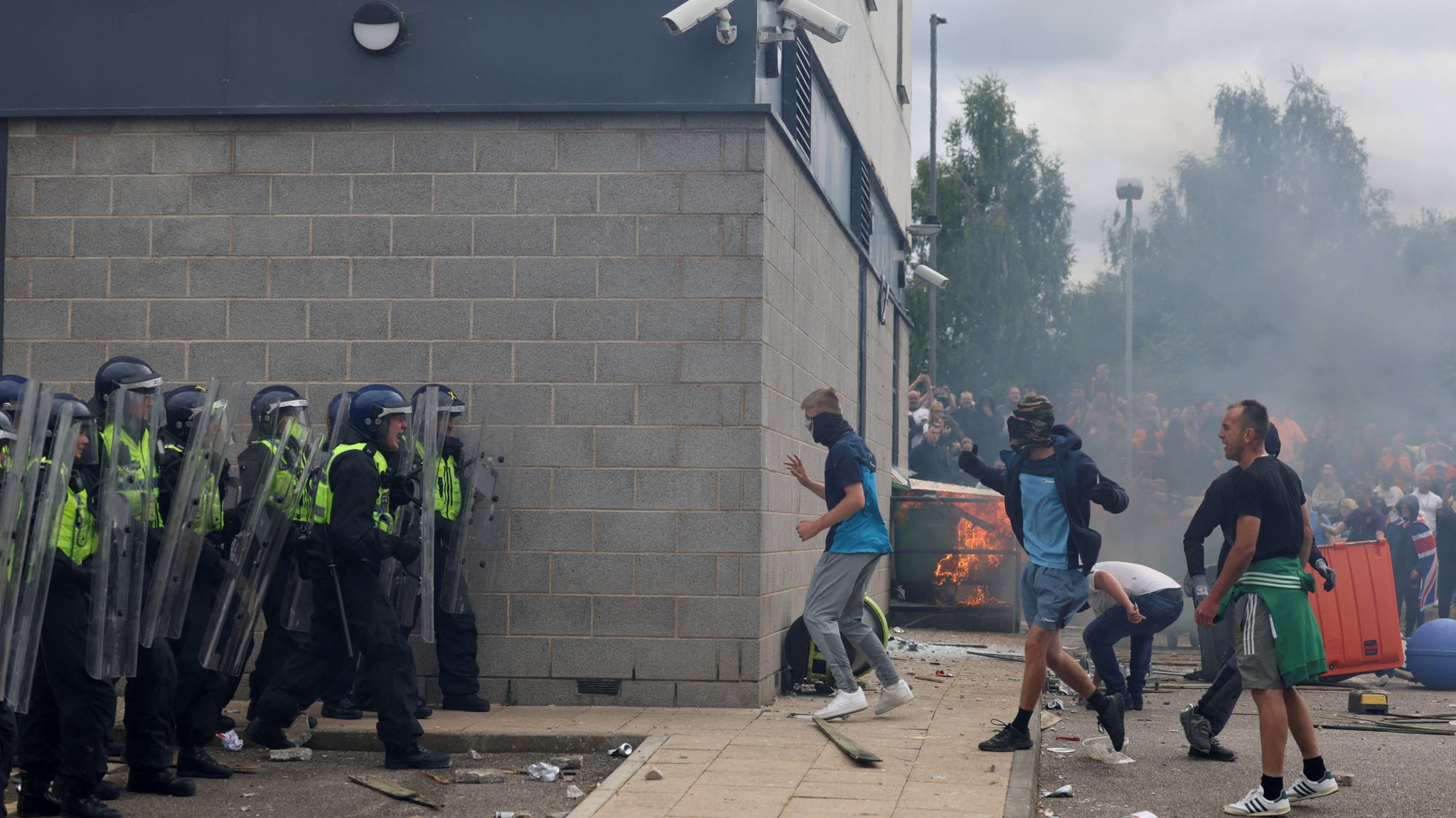 People attacking hotel and police officers with riot shields