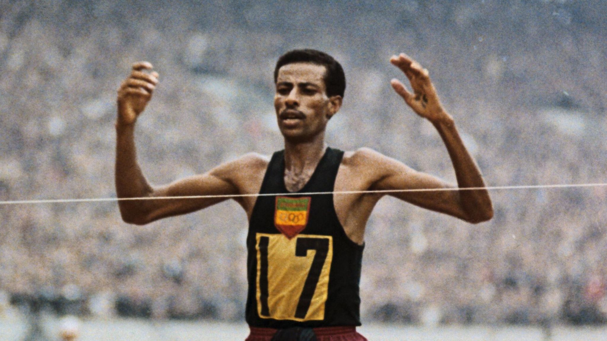 Abebe Bikila in running vest at the finish line of a marathon