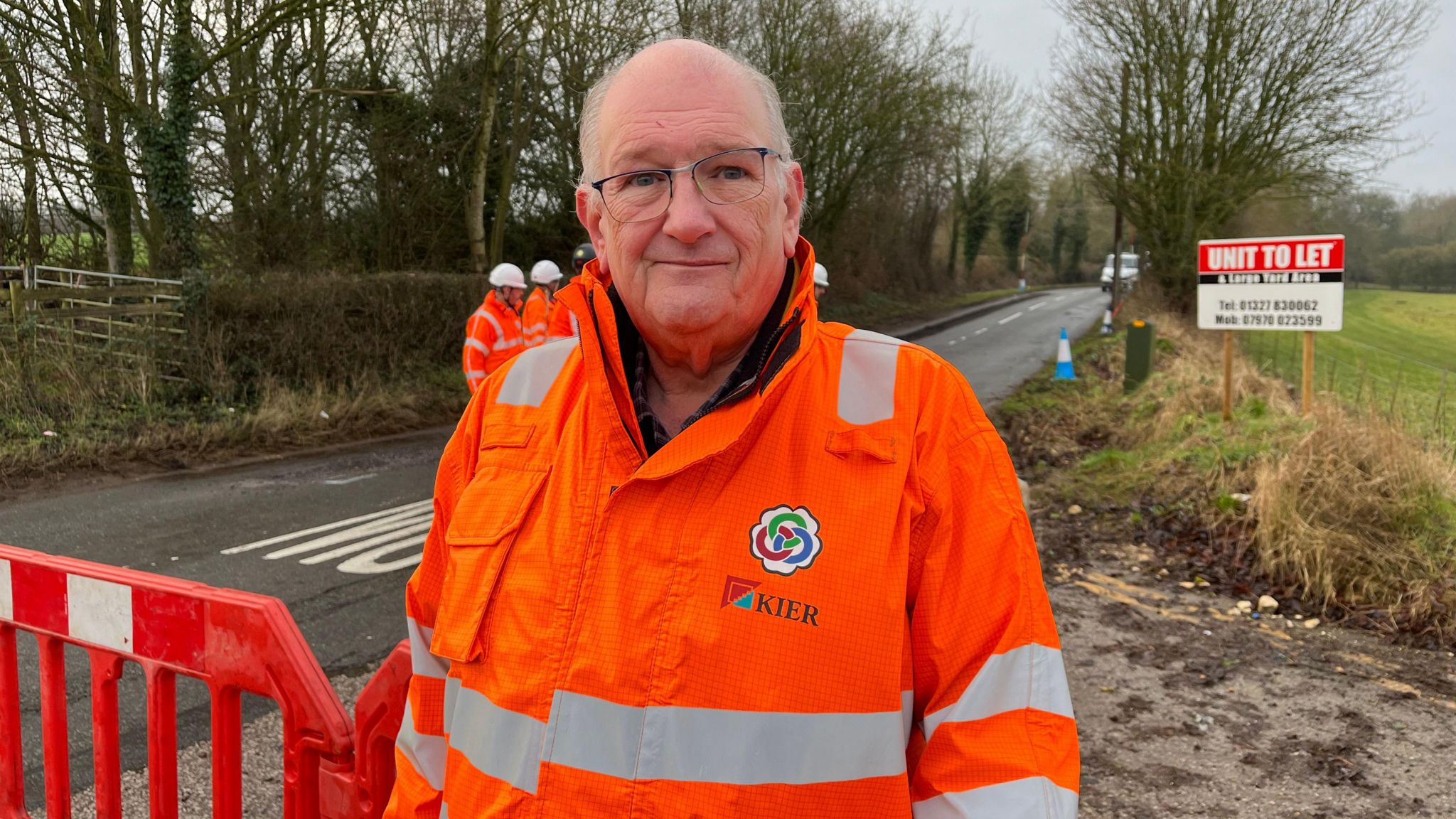 Man wearing a high-visibility jacket standing roadside