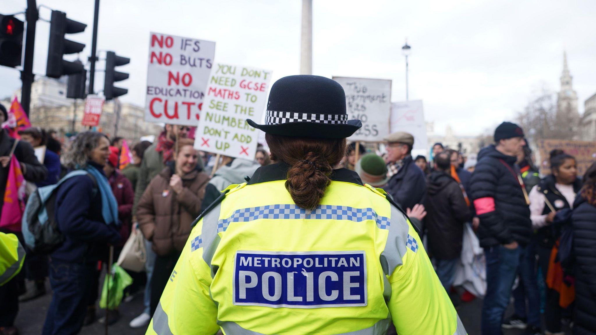 A police officer in front of a crowd in Trafalgar Square