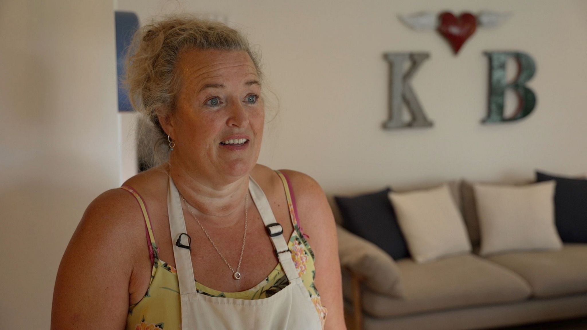 Woman in apron standing in living room of holiday cottage