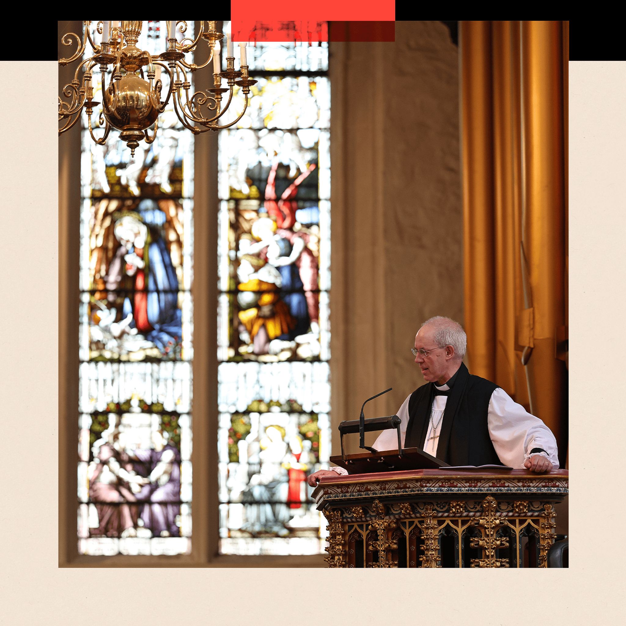 The Archbishop of Canterbury speaks from a pulpit in front of a stained-glass window