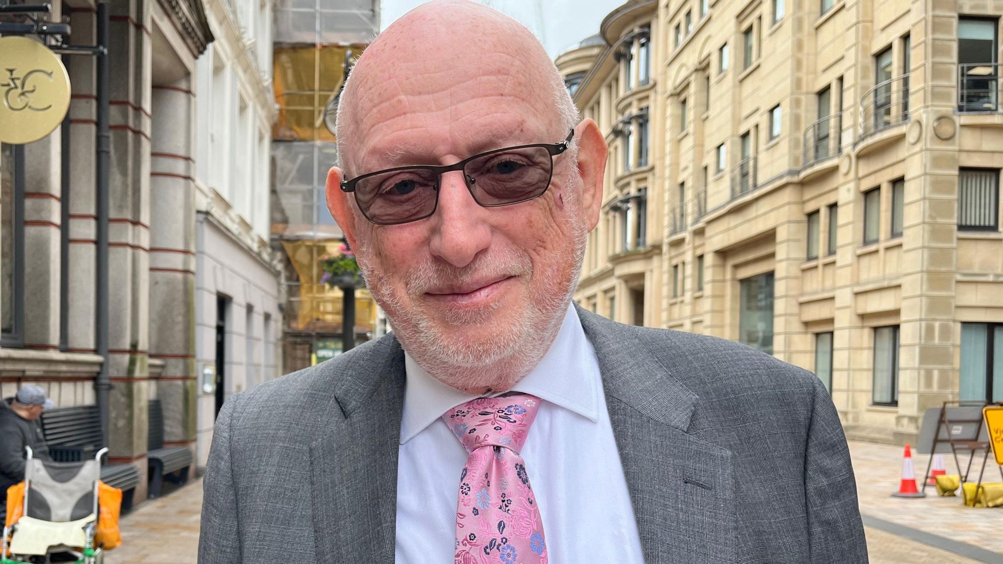 Max Caller, the lead commissioner for Birmingham, wearing a pink tie and standing in a street flanked by buildings