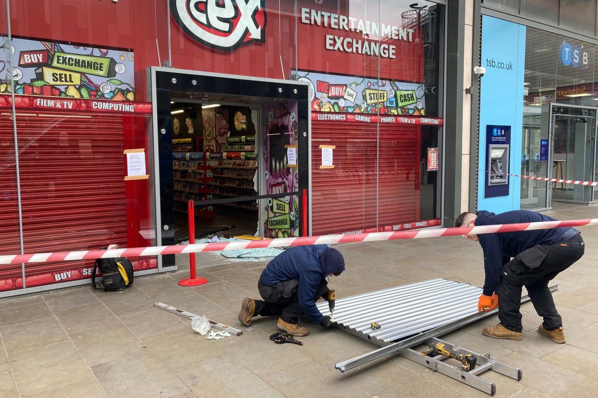Workmen outside the CeX electronics retail and repair shop