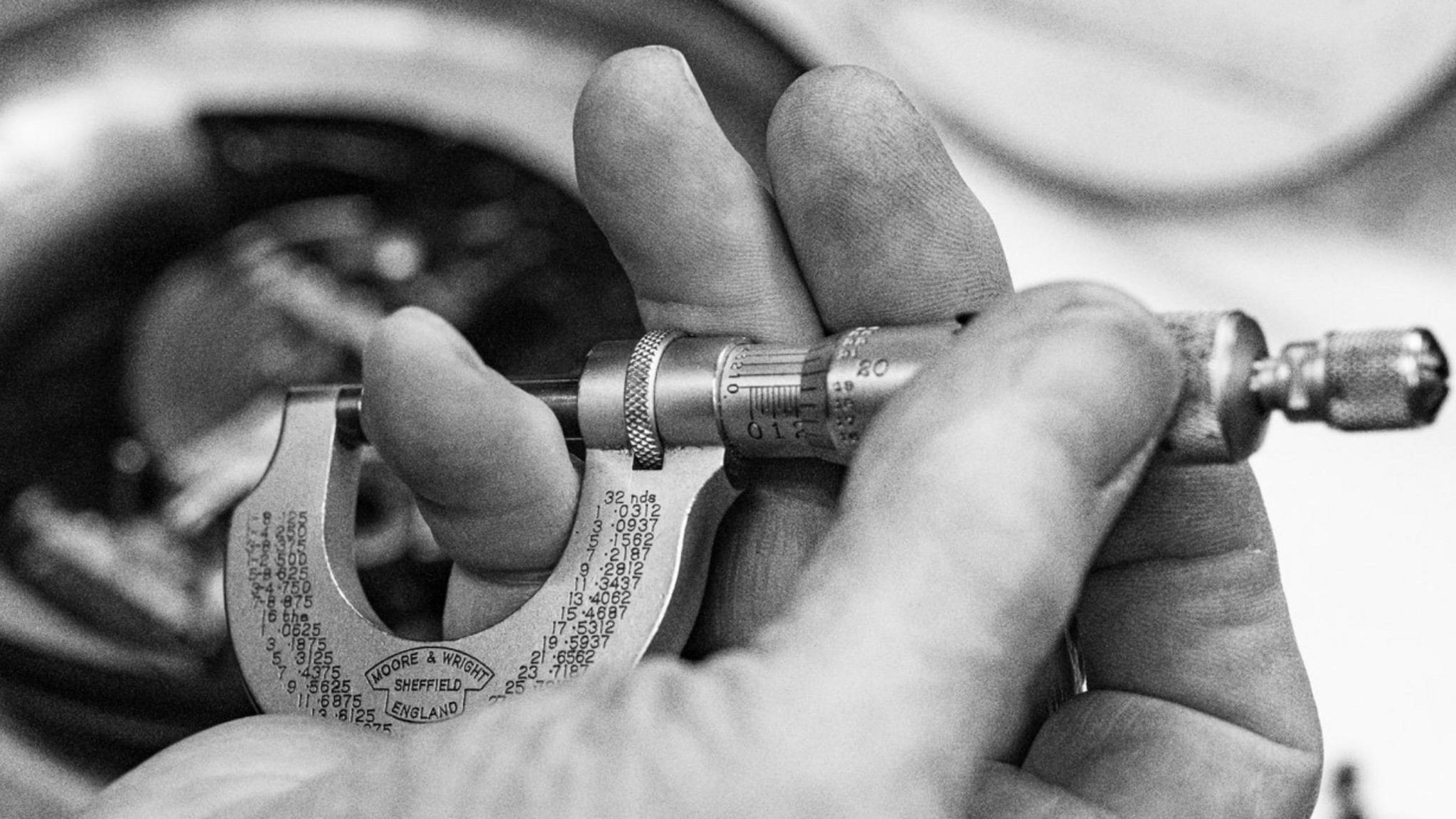 Victor Burness holding a scientific instrument with his fingers.