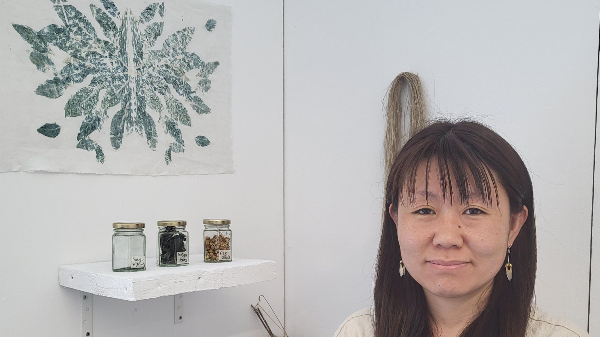 Artist Emi Fujisawa standing by her artwork 