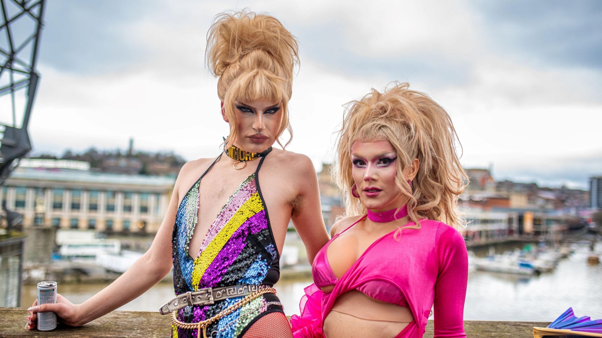 Drag queens UGLY and Miss Venus Wailer in brightly coloured leotards posing by Bristol harbour