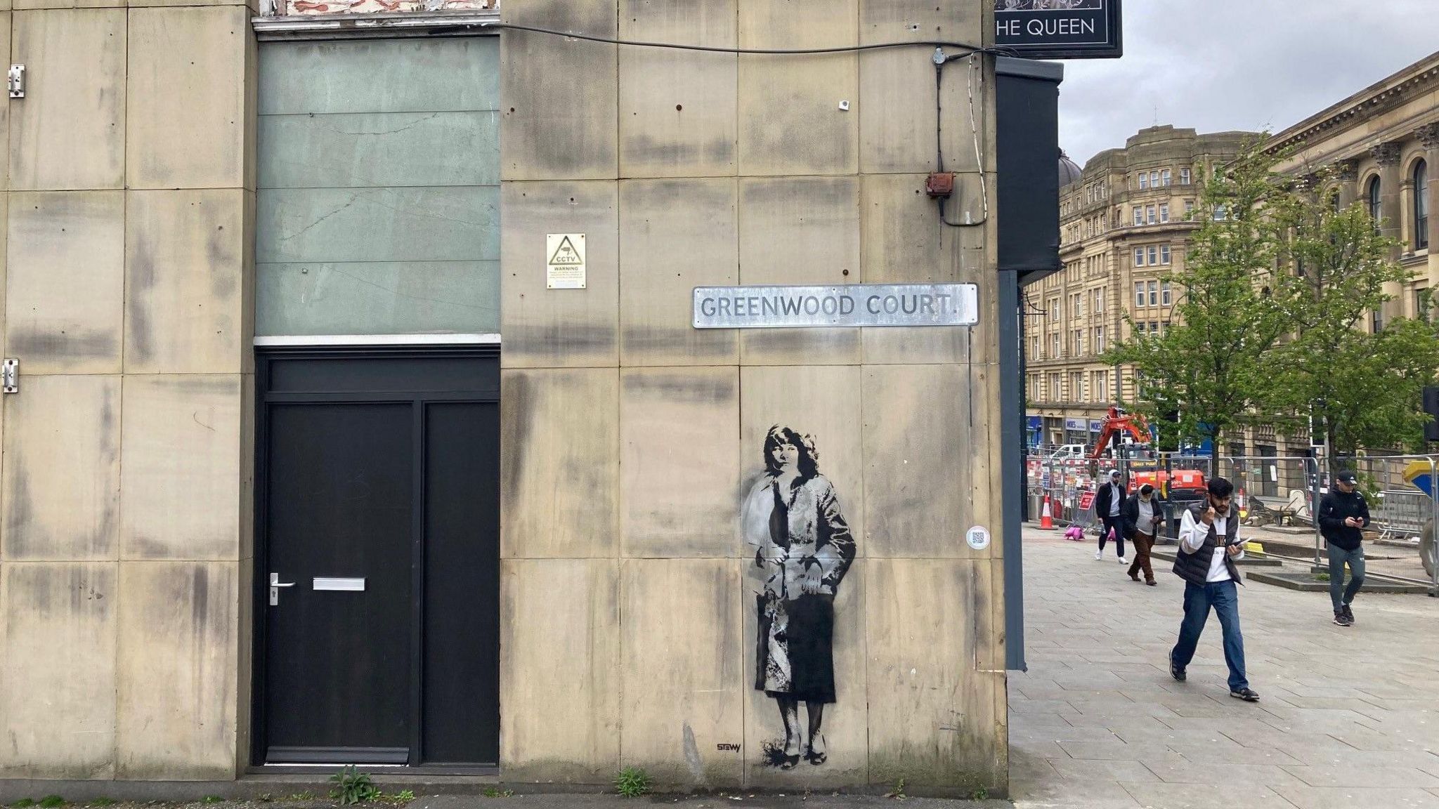 A stenciled artwork of Andrea Dunbar on the side of The Queen pub in Bradford