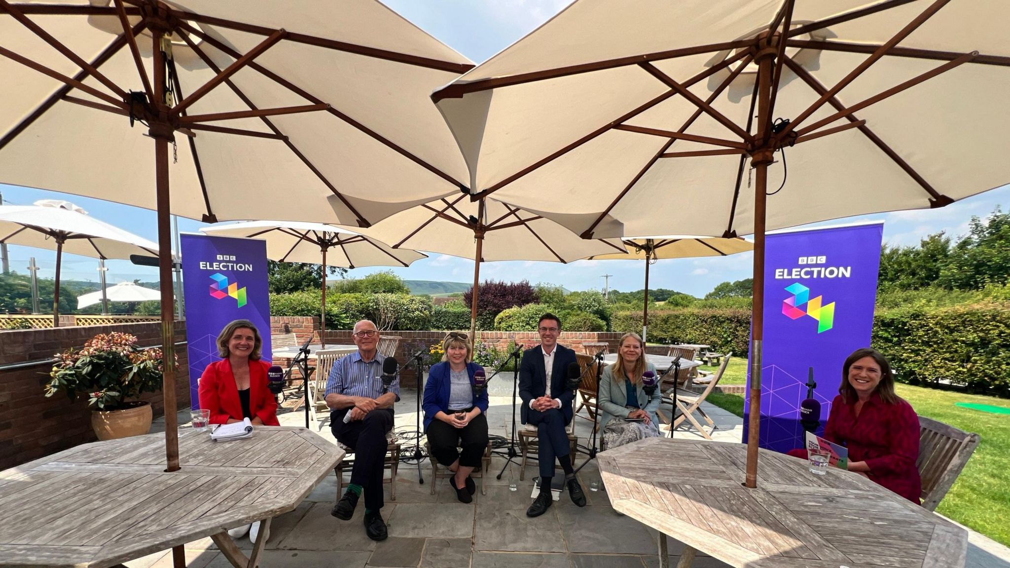 Five political candidates and the BBC's Sussex political reporter in a pub garden