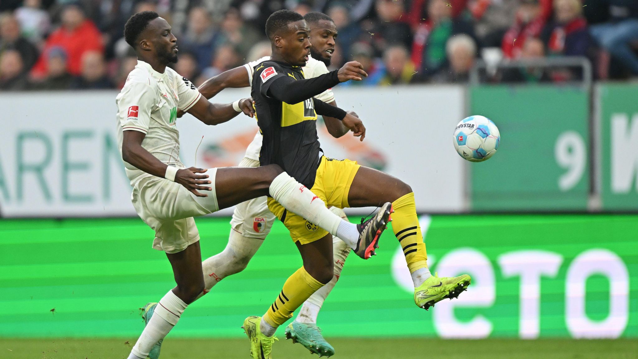 Borussia Dortmund winger Jamie Gittens battles for the ball during the defeat to Augsburg