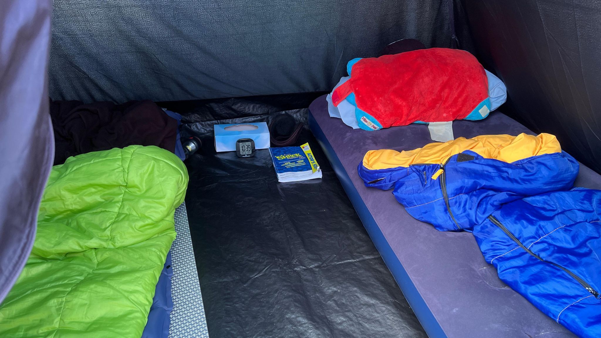 An inflatable mattress and sleeping bag inside Joshua's tent 