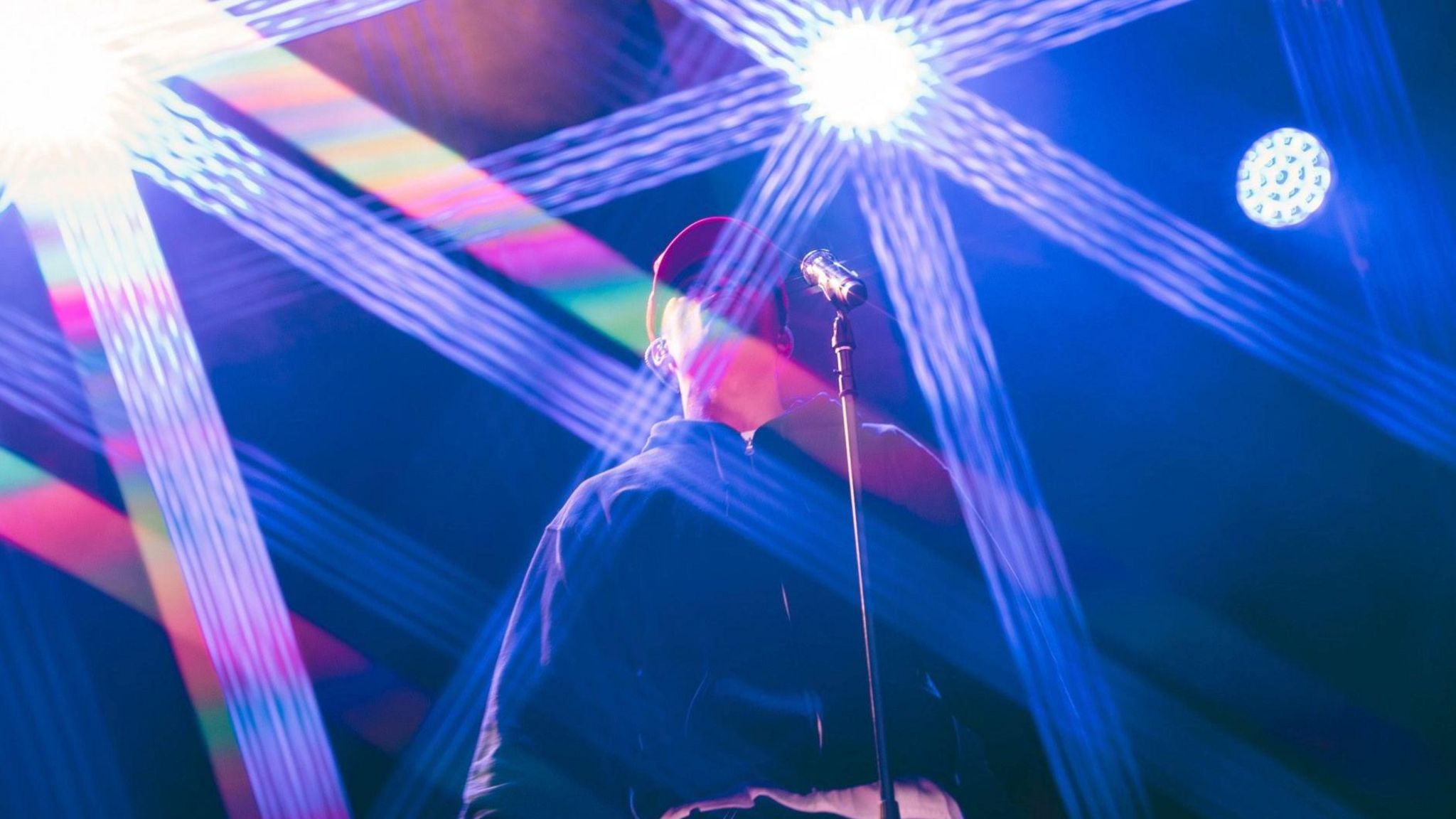 Loyle Carner on stage with lights behind them