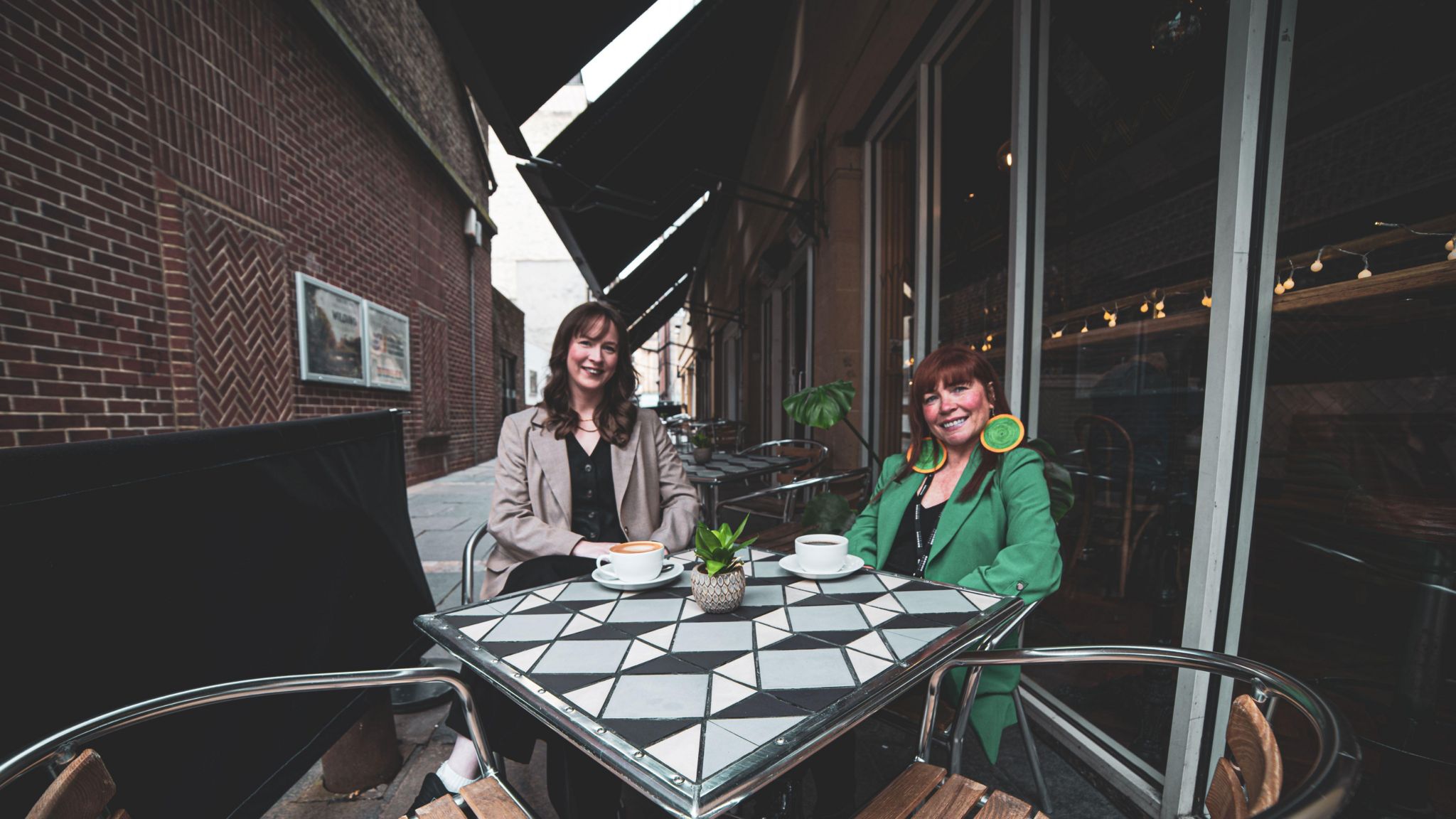 Naomi Allen Seales, Investment Manager at Northstar Ventures, with Nic Greenan, chief executive officer at the Tyneside Cinema, sitting outside at a table with cups of tea and coffee