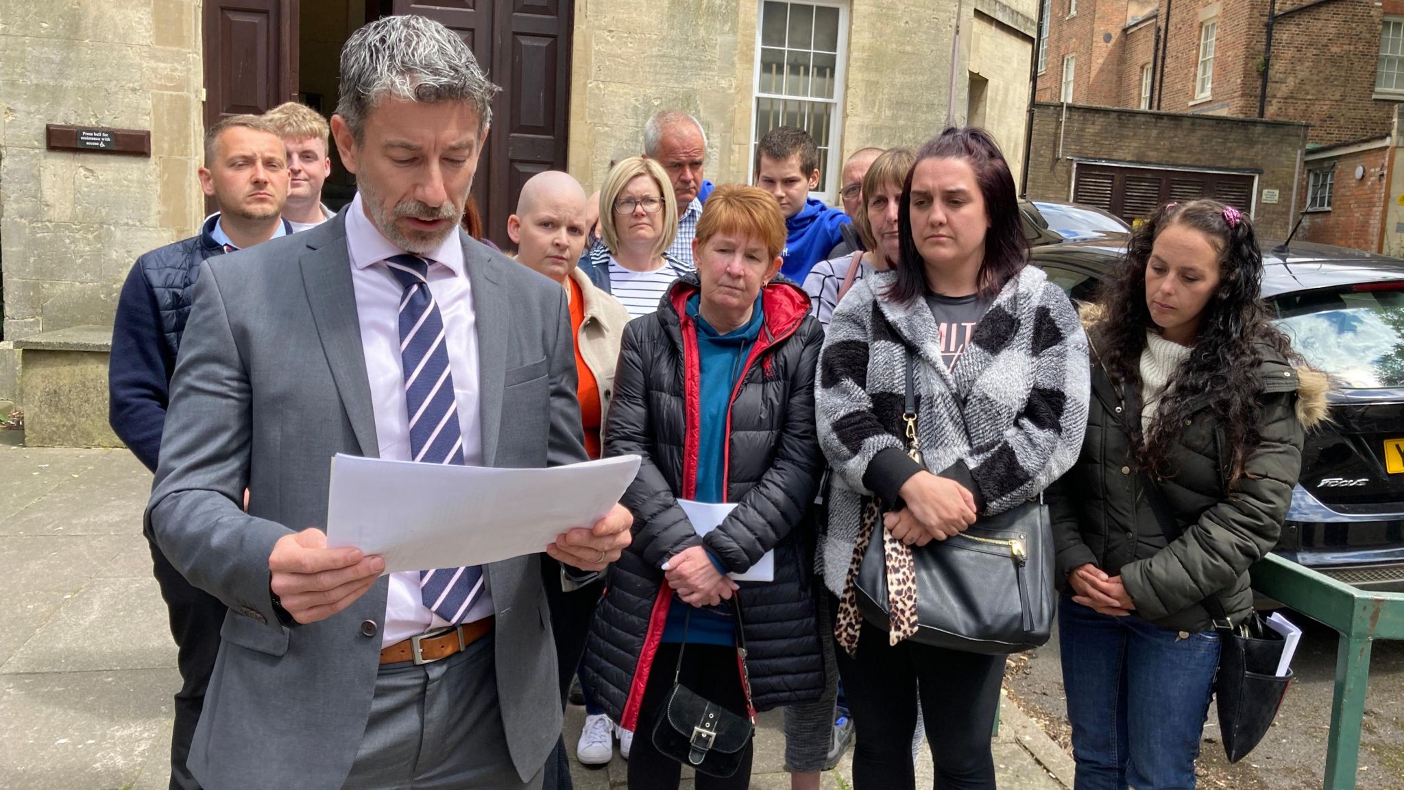 DI Adam stacey reading family statement with Mr Hopkins' family behind