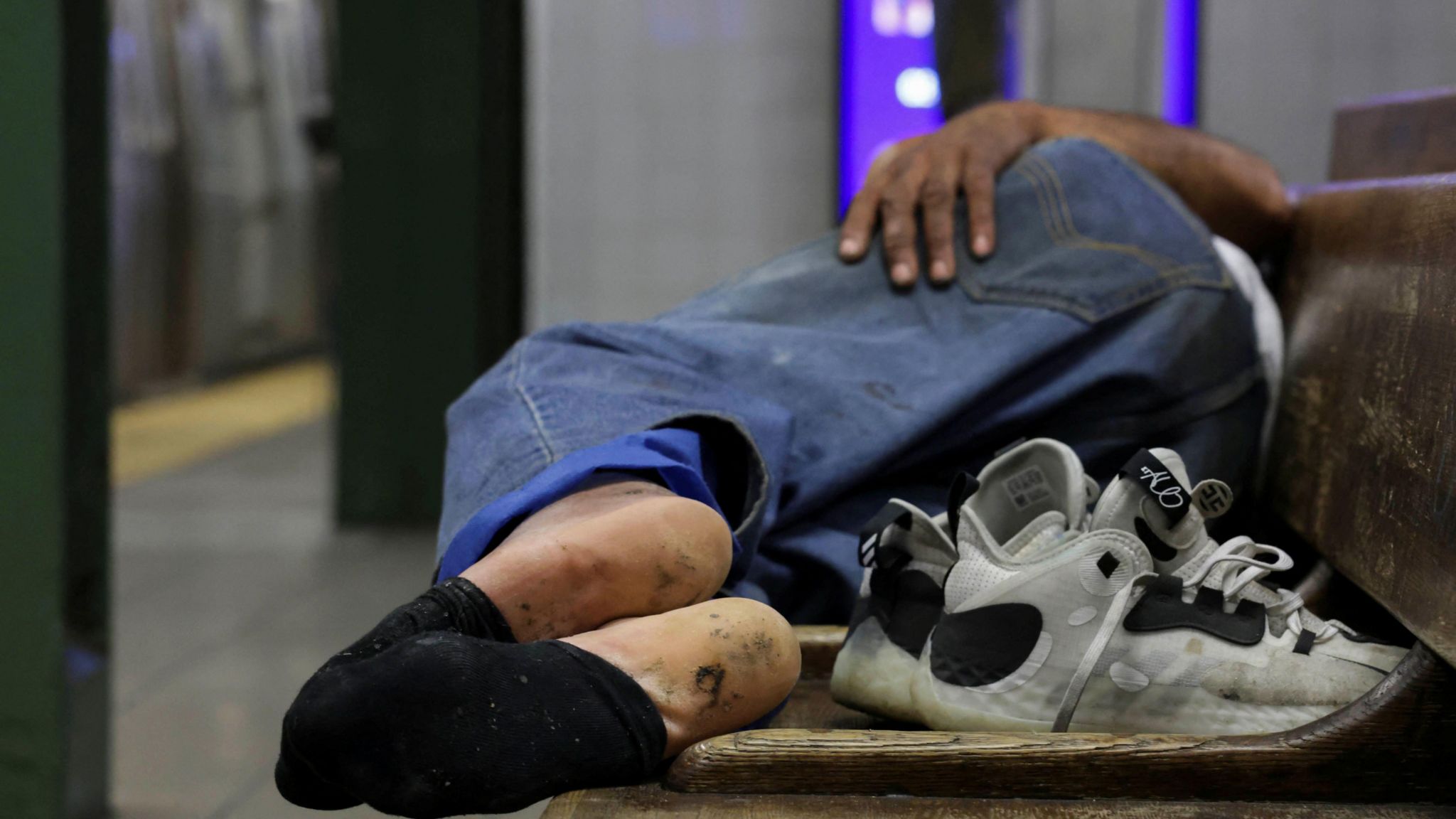 A homeless man sleeping on a bench