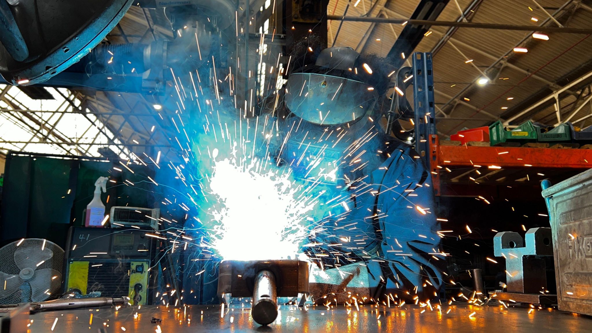 Gordon during his welding job. Sparks can be seen flying off metal