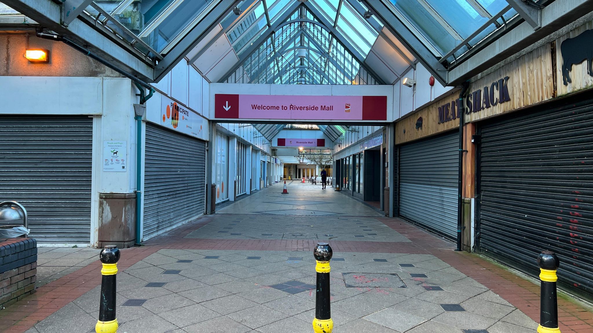 The entrance of the old Riverside shopping centre with boarded up shops