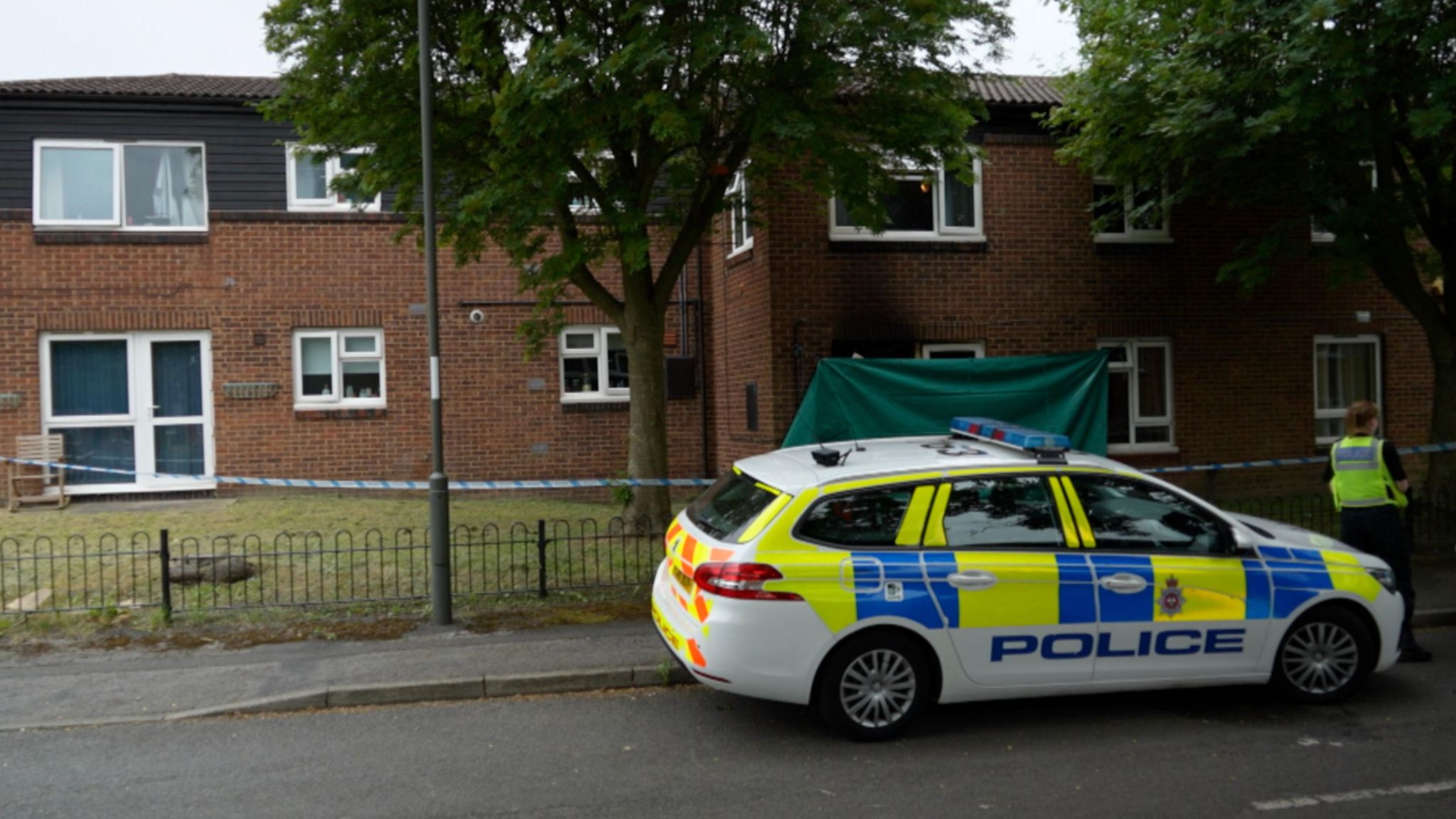 A photograph of a cordon and police car outside a flat, which was involved in a fire