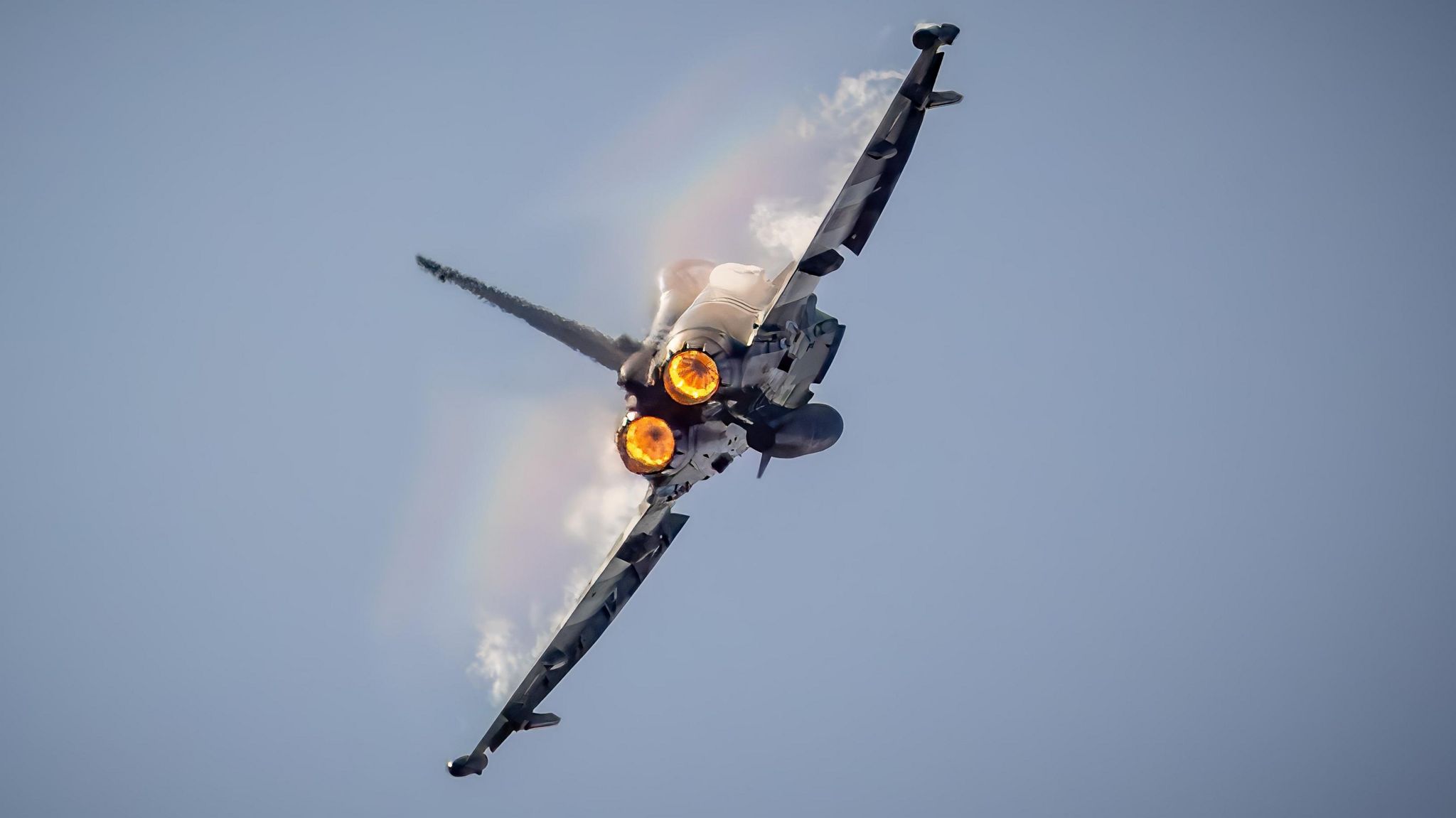 An RAF Typhoon fires its afterburners as it travels away from the camera