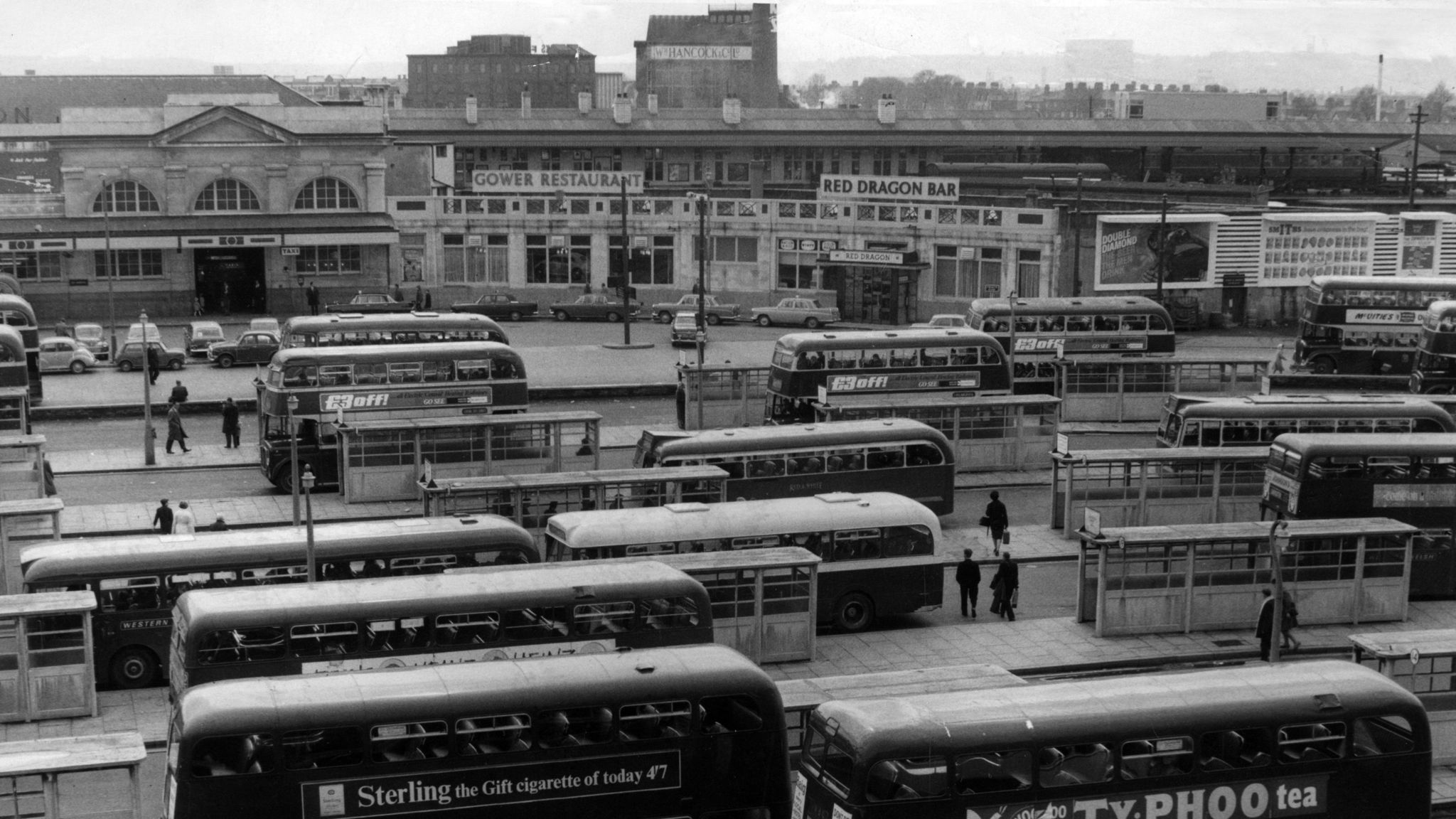Black and white photo of Cardiff's former bus station. It shows buses lined up in the bays in the station