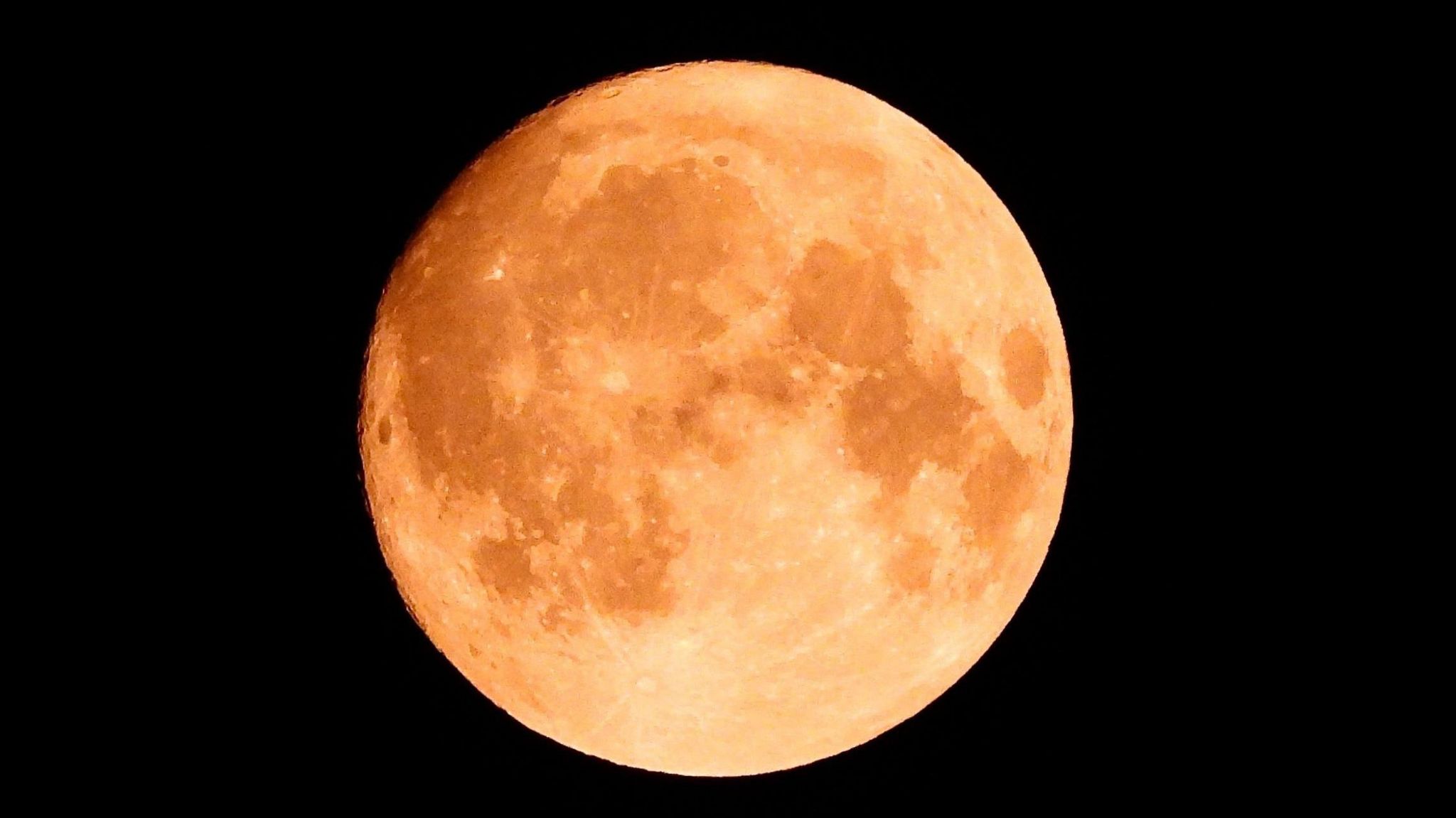 black night sky with the full moon filling the picture.  Some detail of the topography of the moon which has also turned orange.